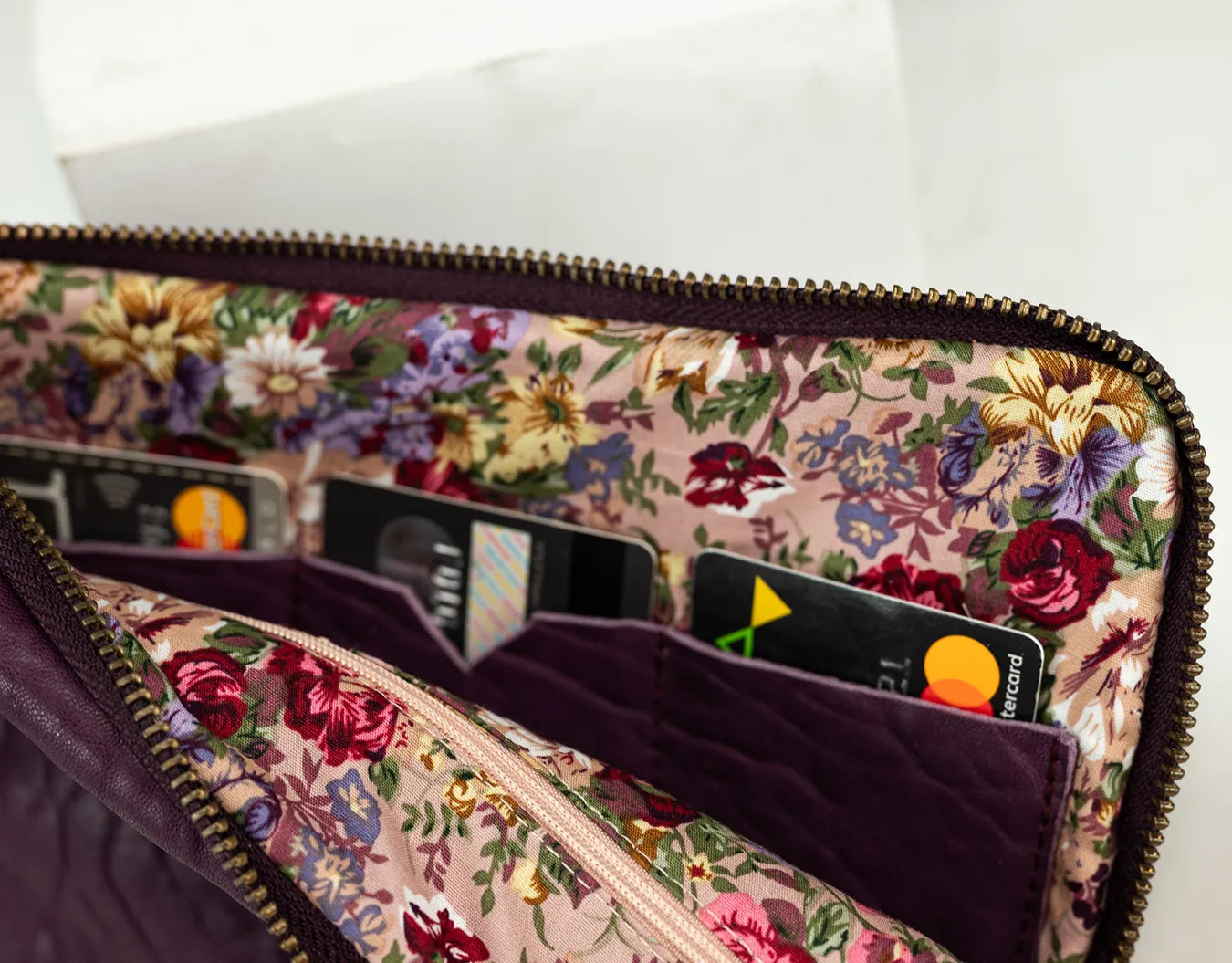 Floral-patterned wallet with cards inside on a white background