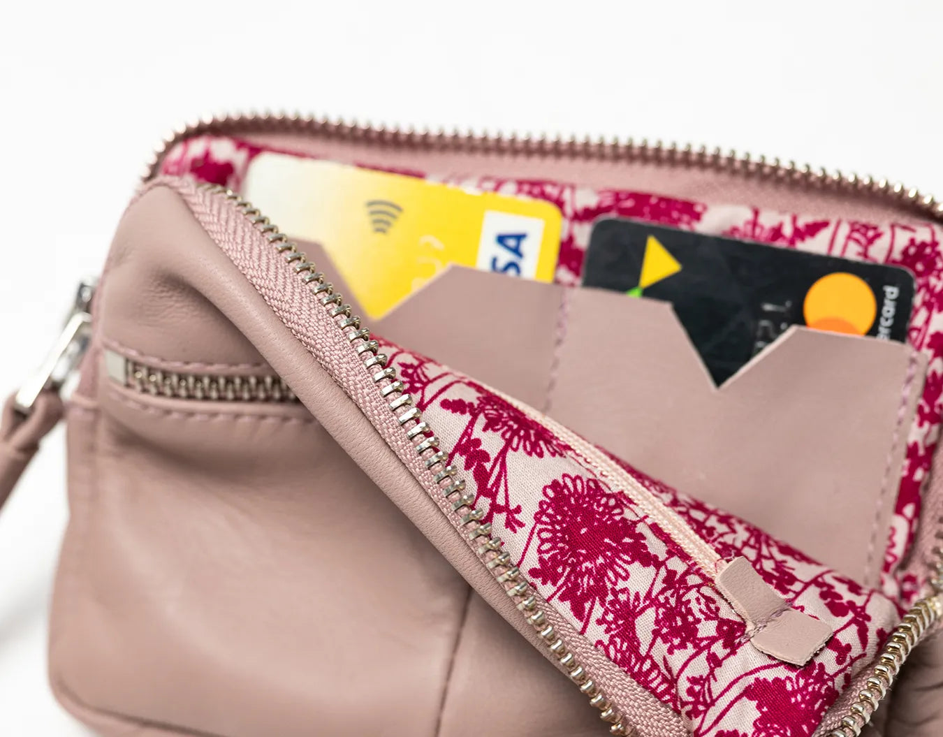 Pink floral-patterned wallet with cards inside on a white background