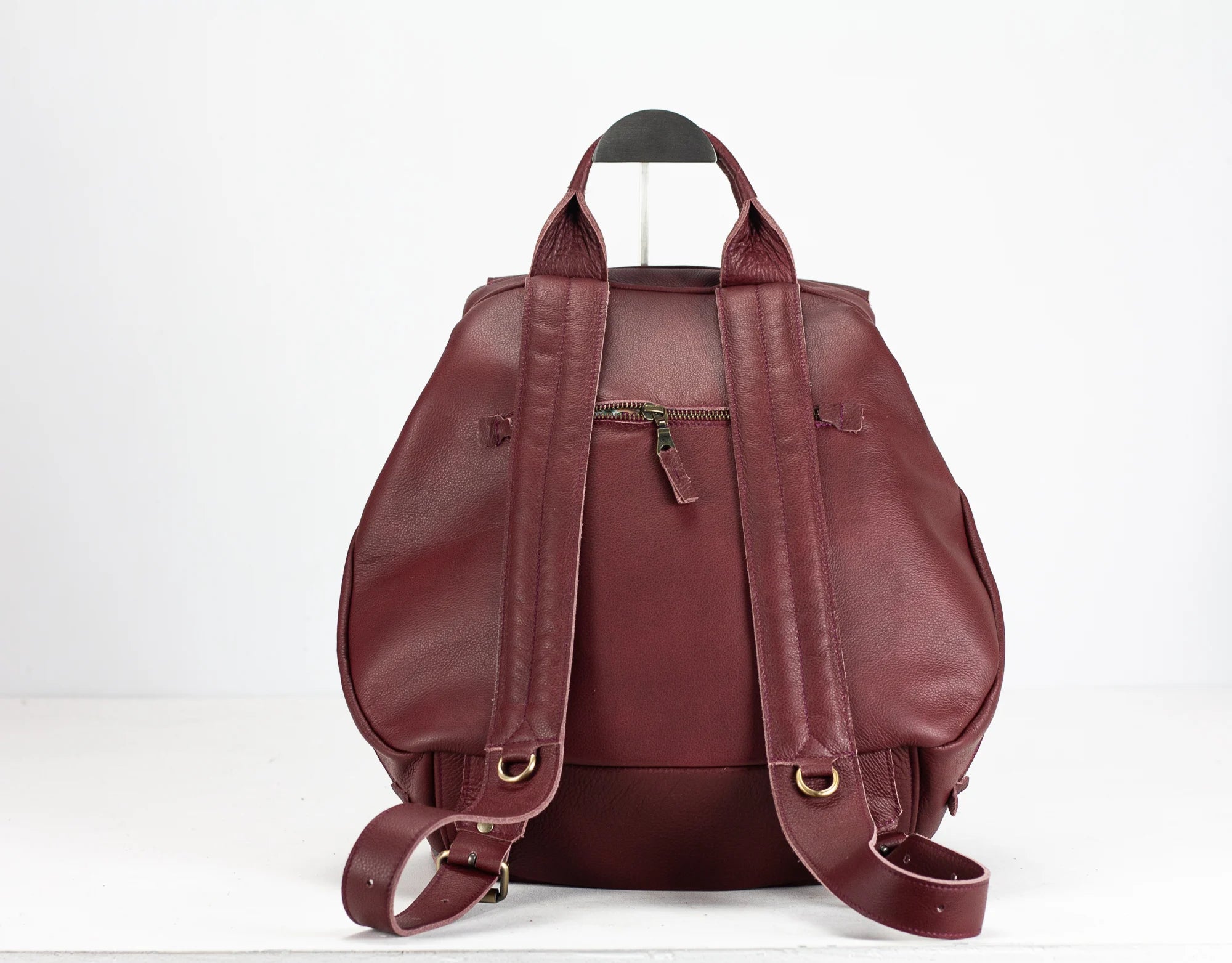 Maroon leather backpack on a white background