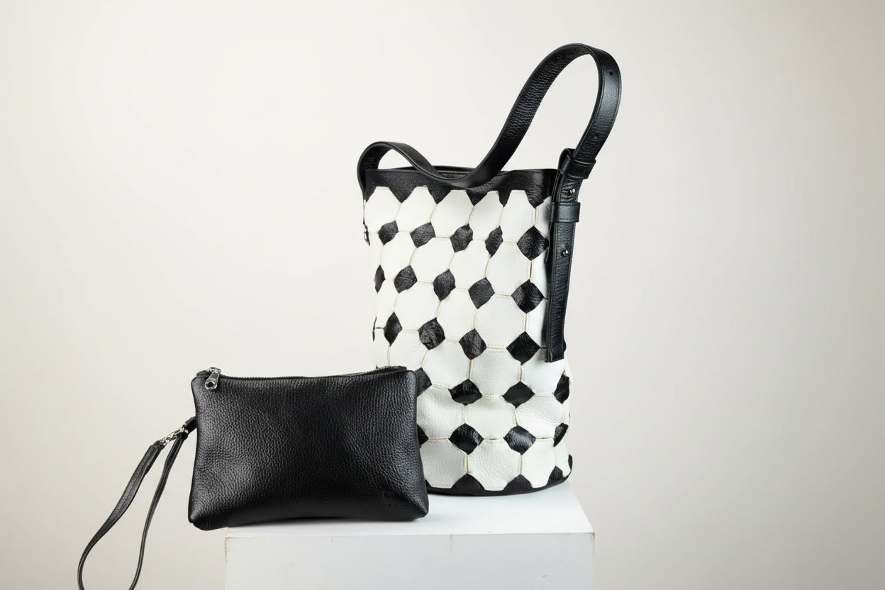 Black and white woven handbag with a matching clutch on a gray background