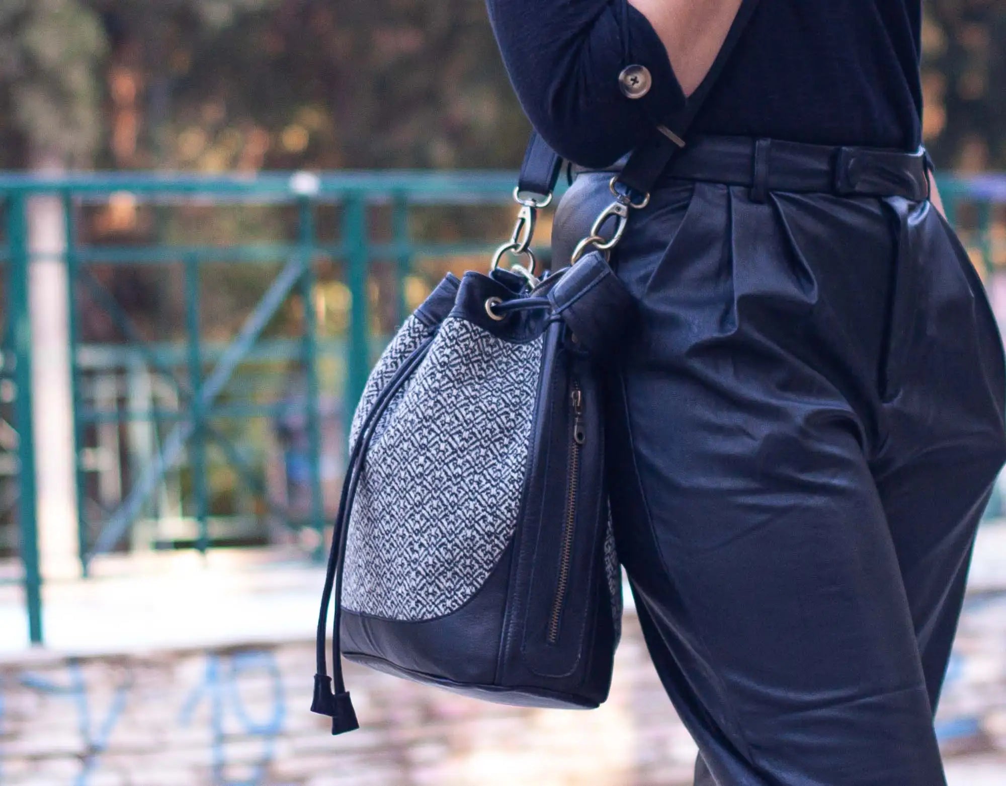 Person wearing a navy blue outfit with a textured black and gray bag.