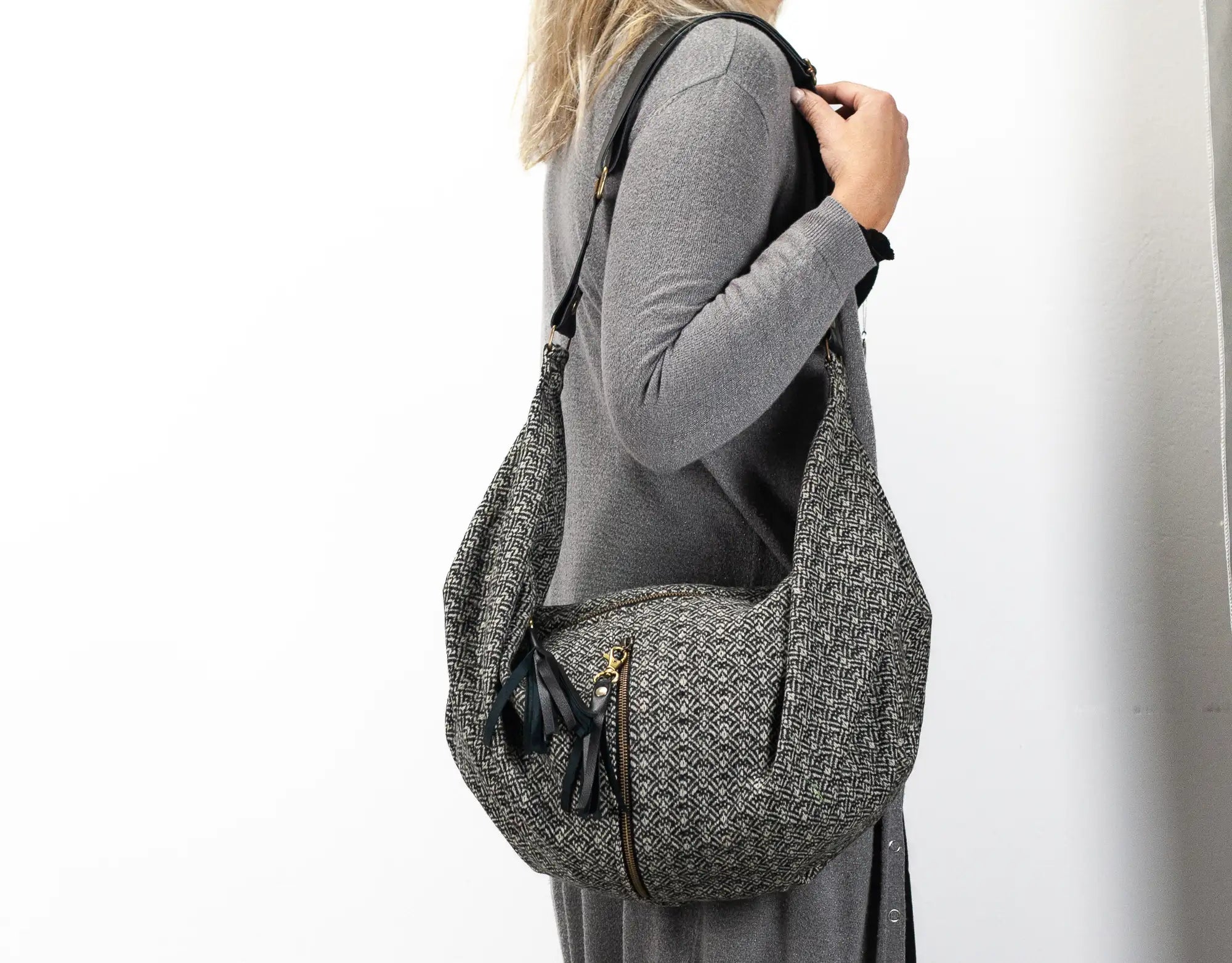Person wearing a gray textured backpack on a white background