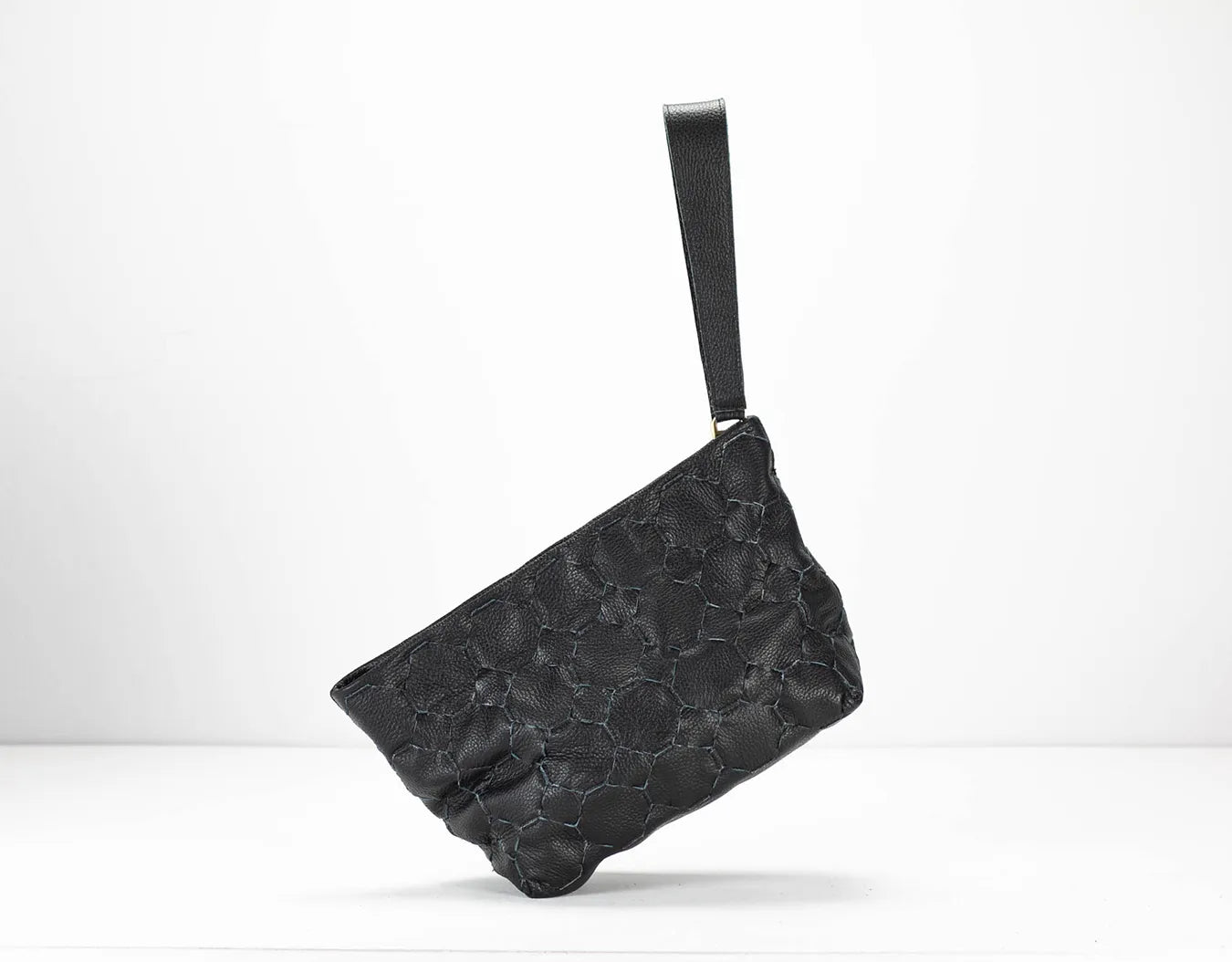 Black textured clutch bag on a white background