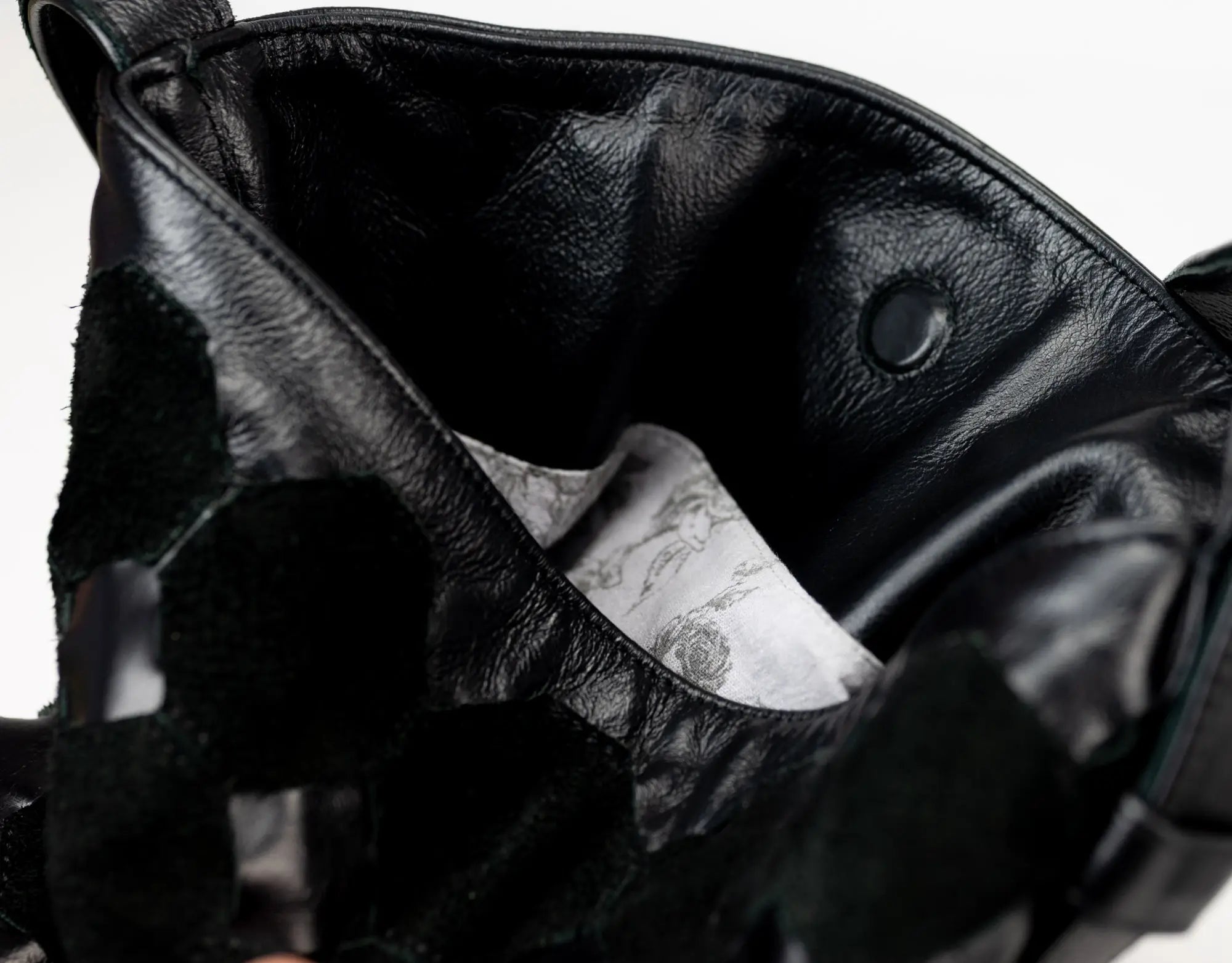 Close-up of a black leather jacket with a brand label inside