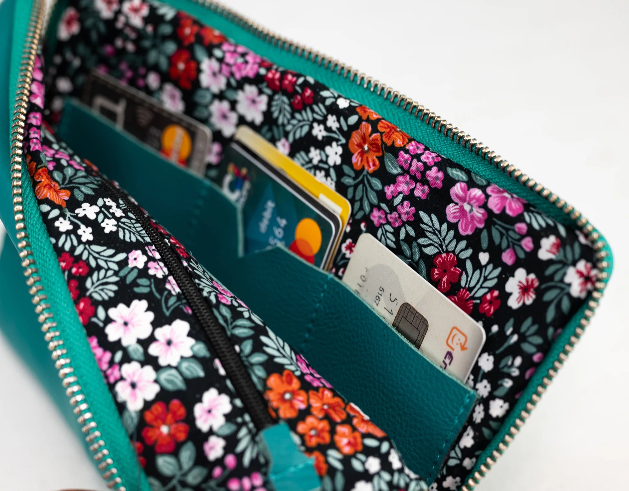 Floral-patterned wallet with cards inside on a white background
