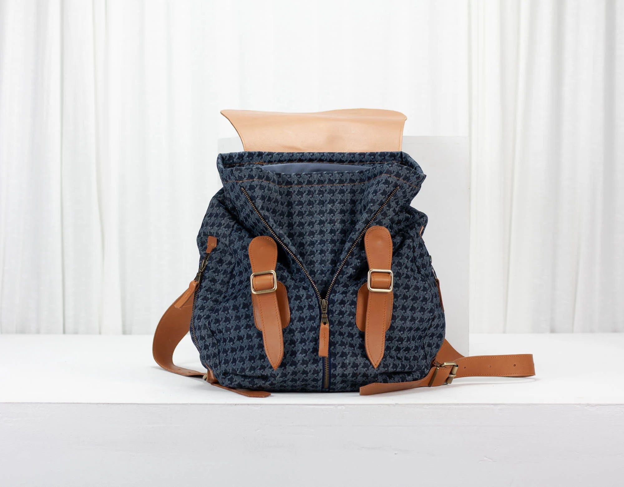 Blue patterned backpack with brown straps on a white background