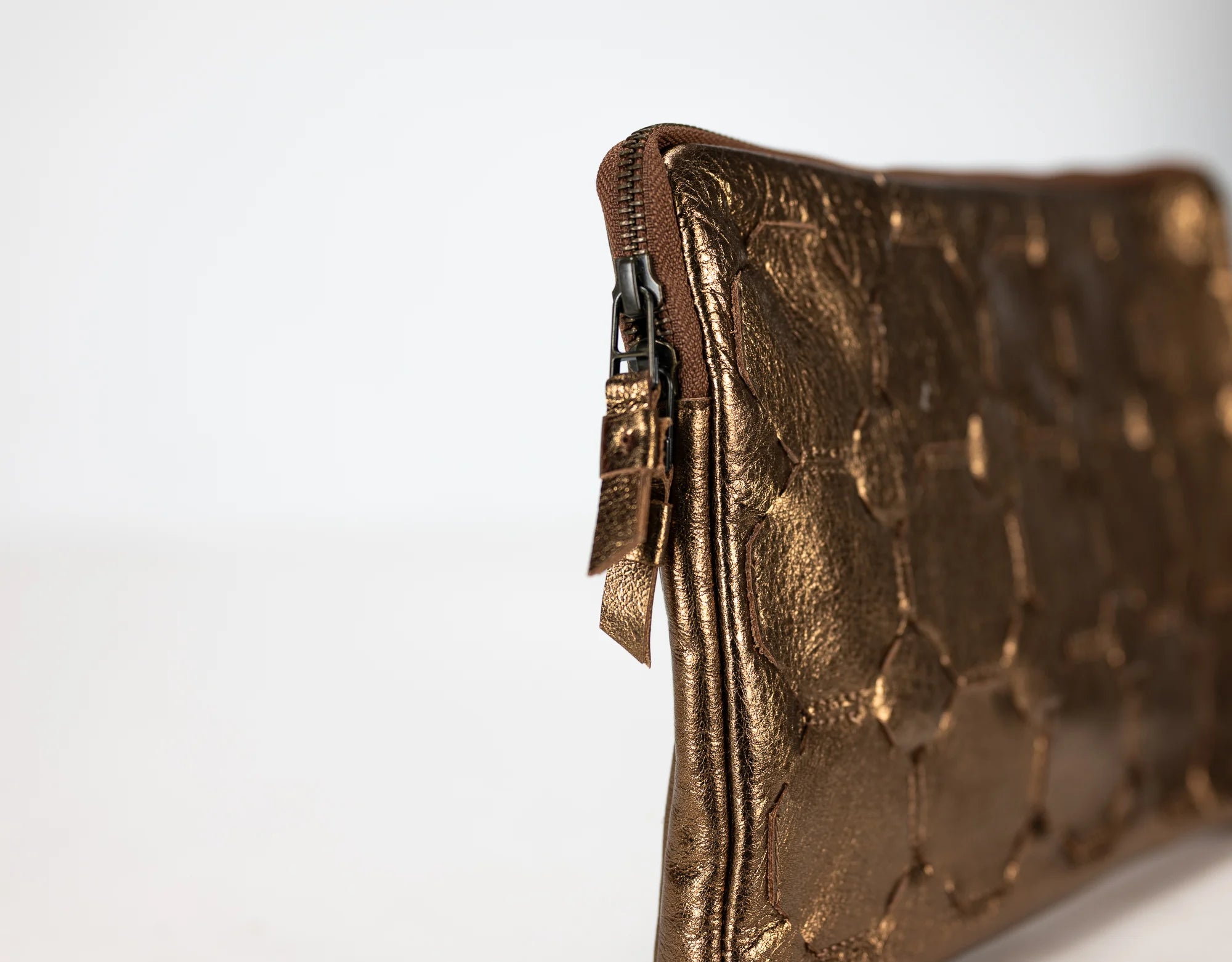 Bronze textured clutch bag on a white background