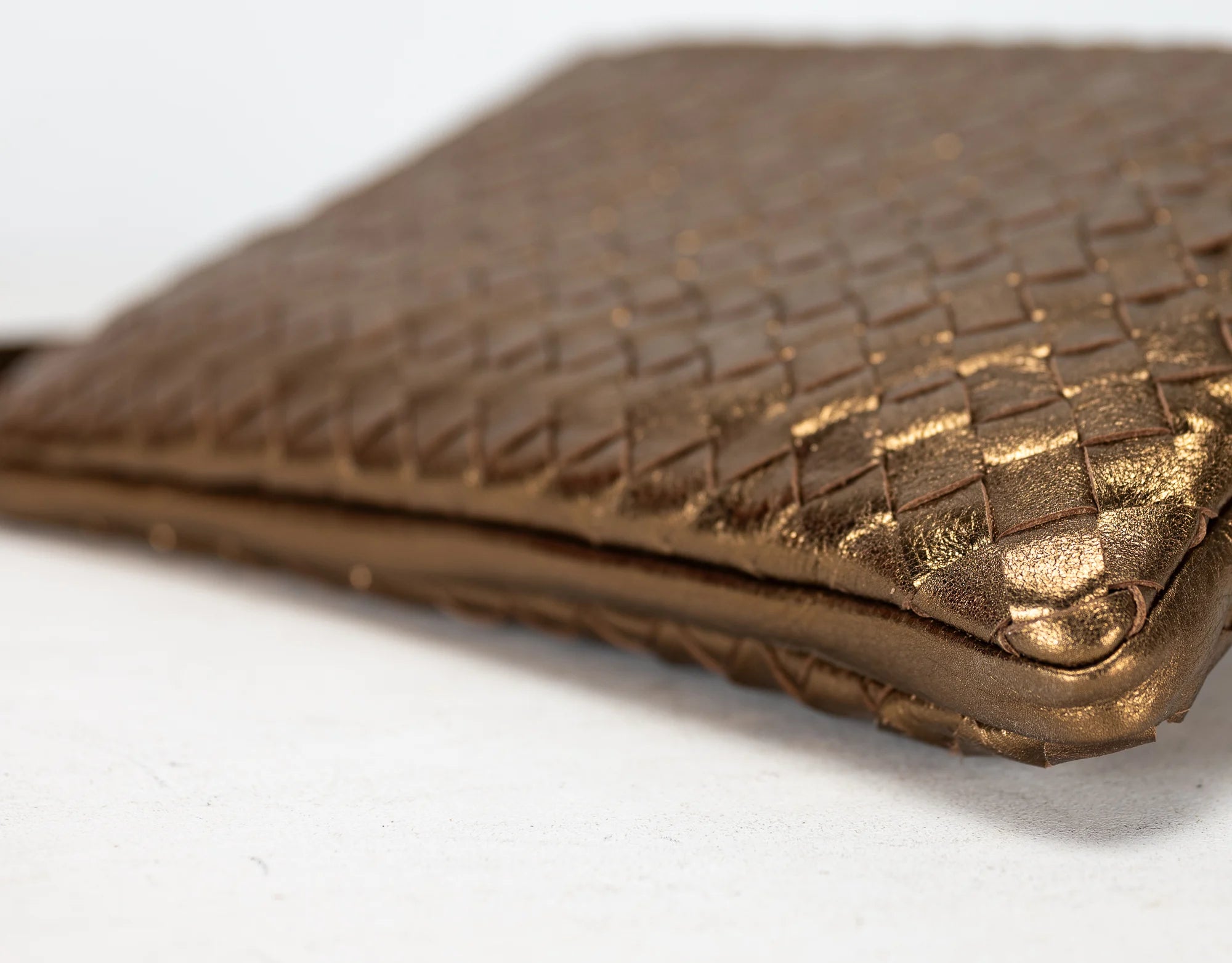 Gold textured clutch bag on a white background