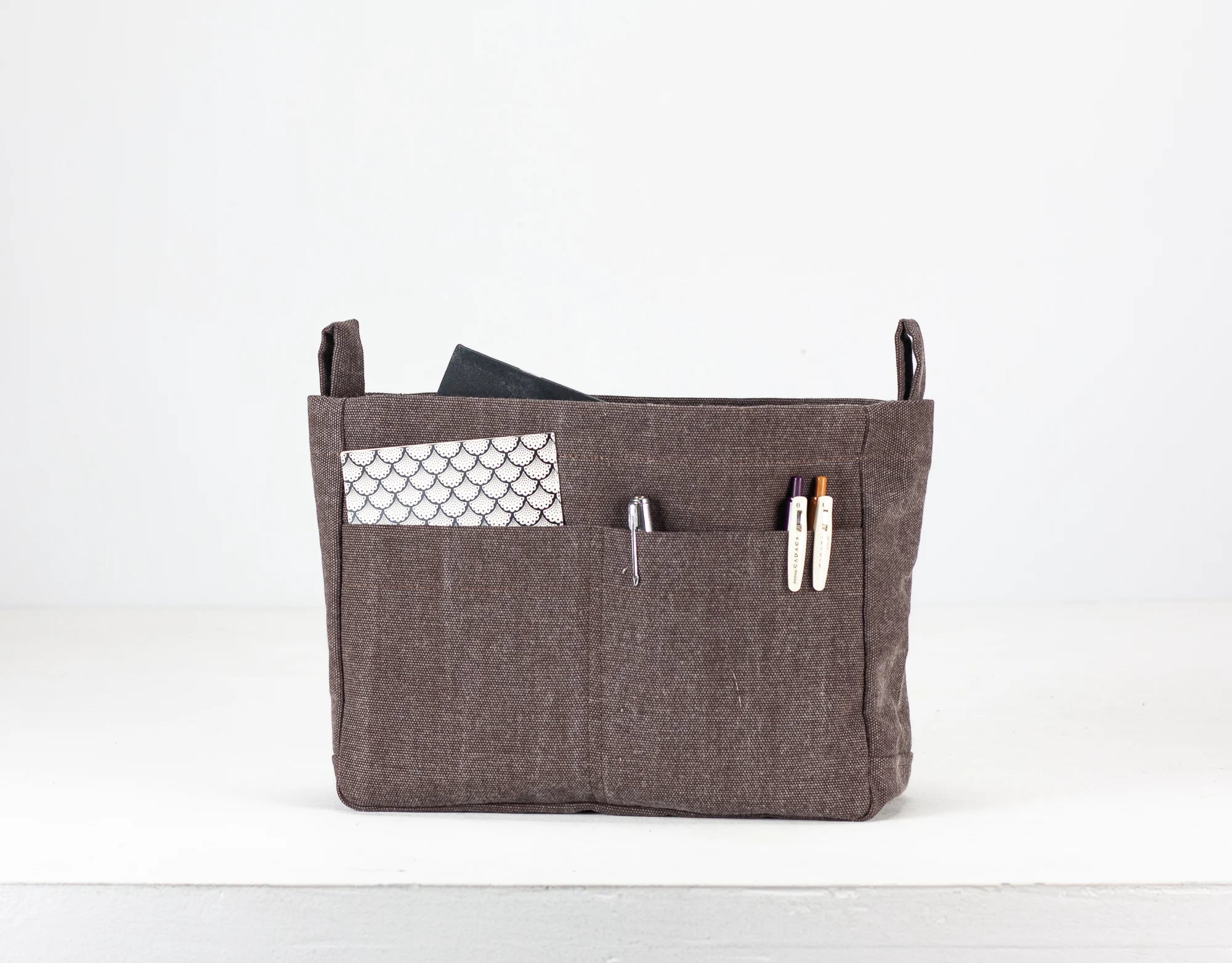 Brown fabric bag with pockets on a white background