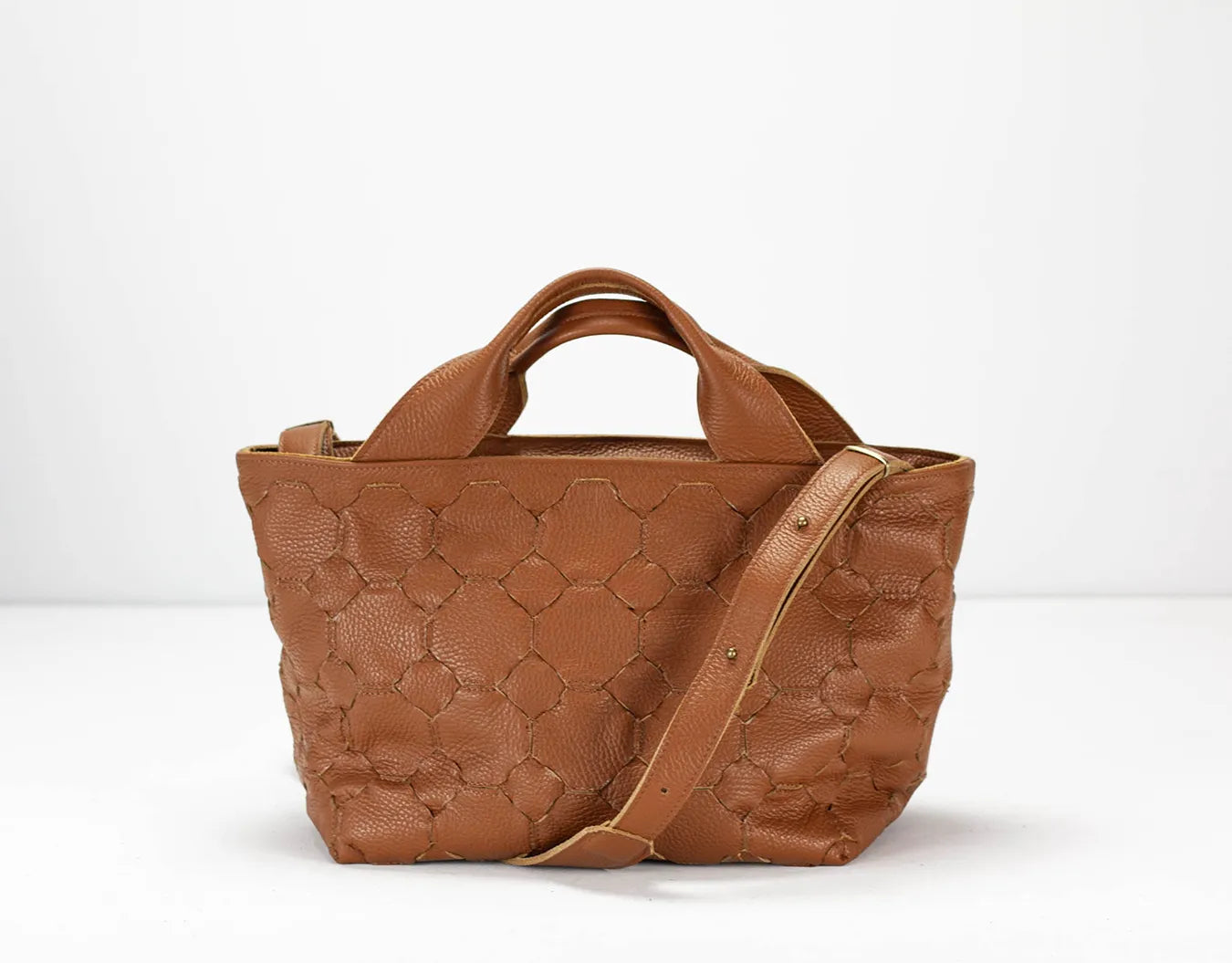 Brown textured handbag with a shoulder strap on a white background