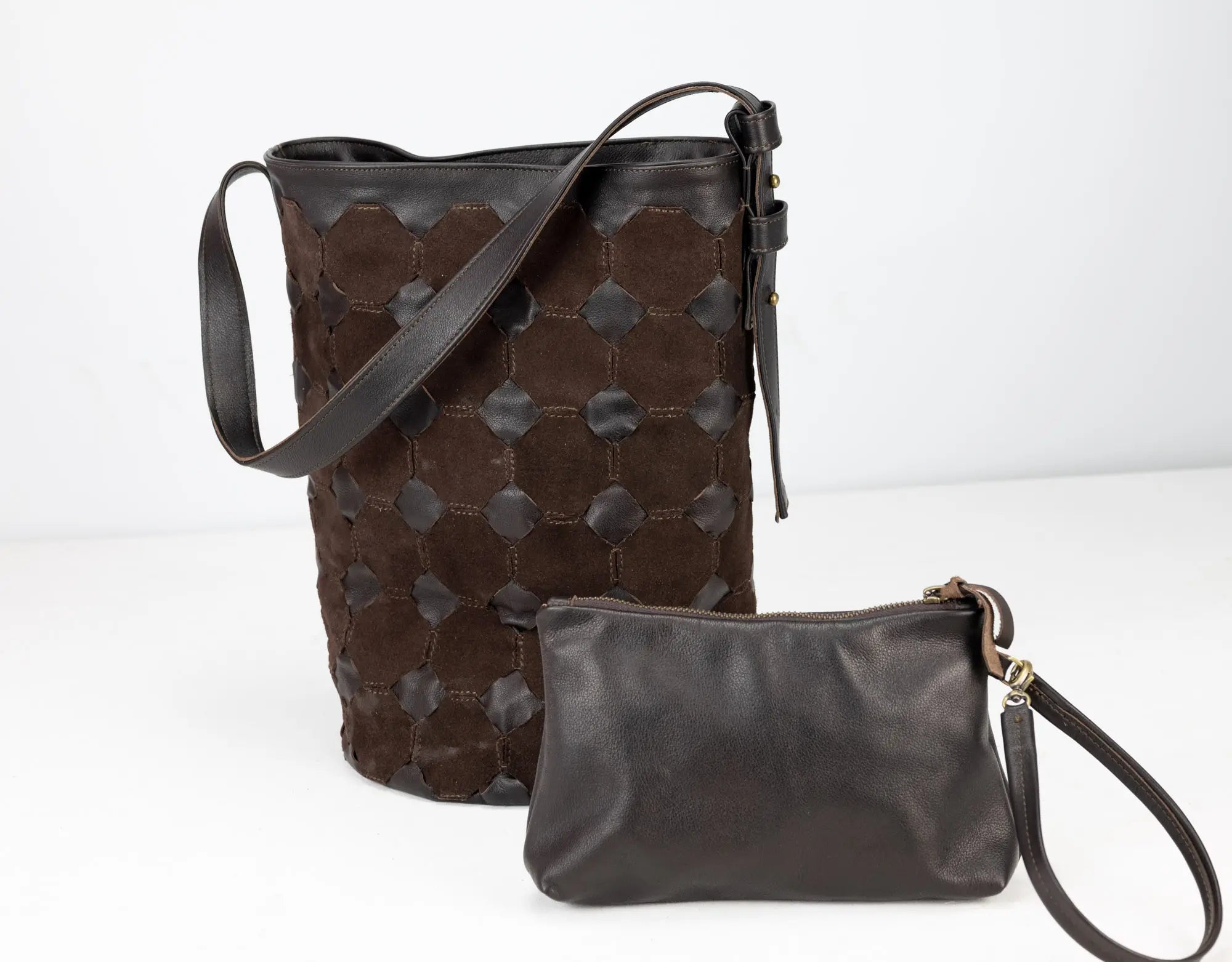 Brown leather bucket bag and matching wristlet on a white background