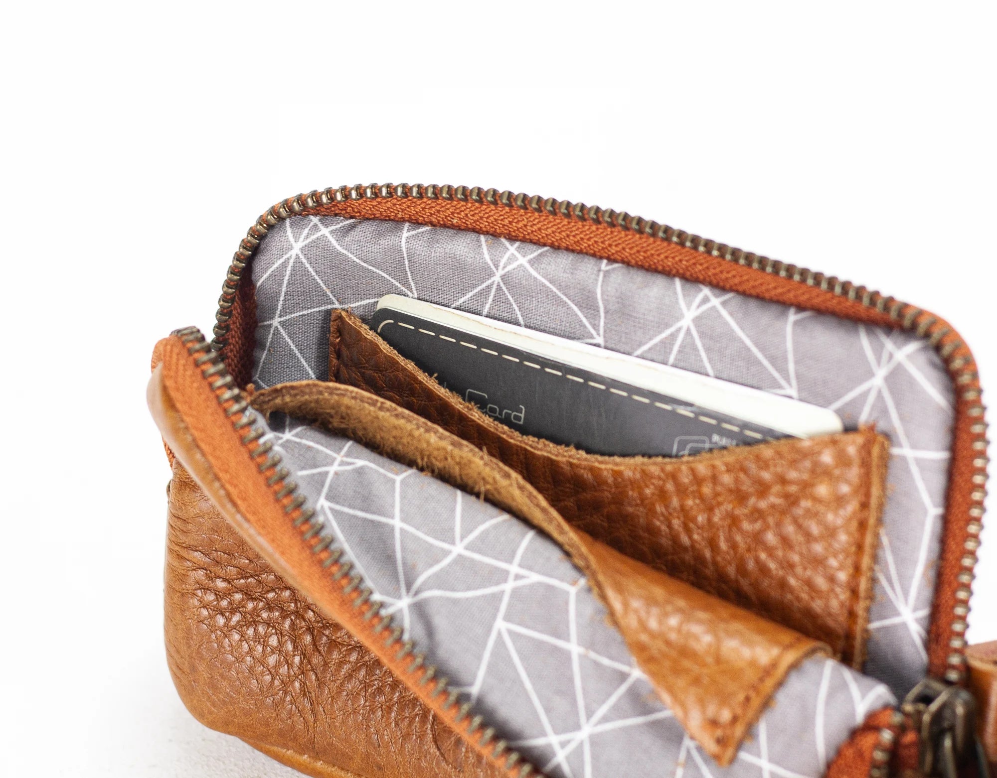 Brown leather wallet with geometric patterned interior on a white background