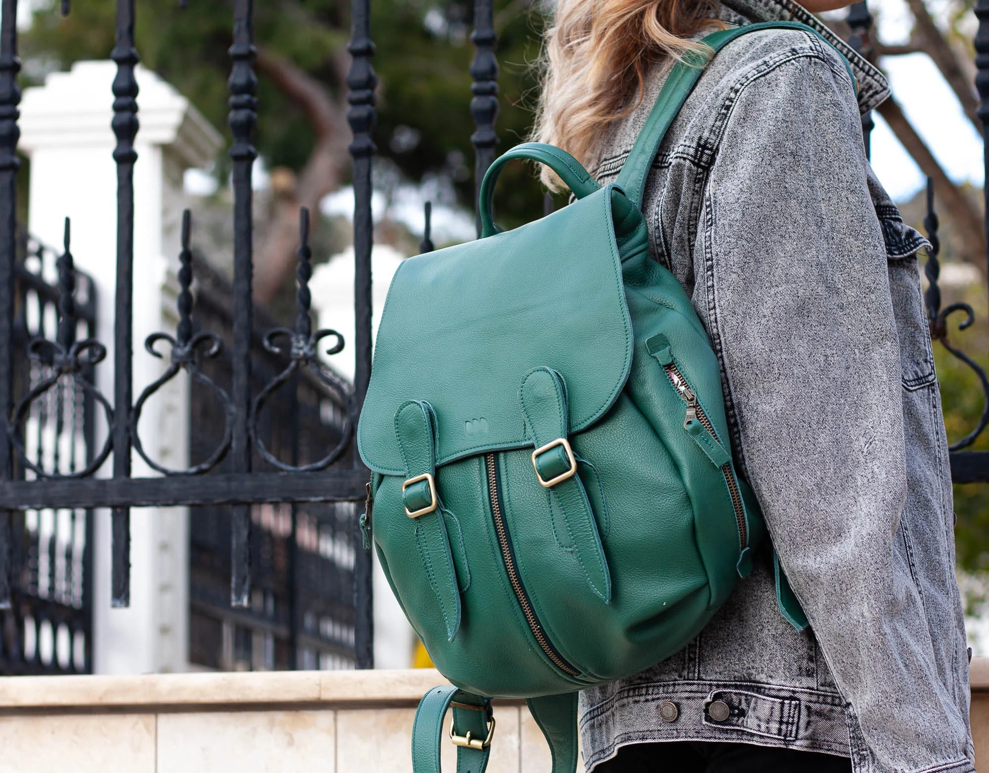 Person wearing a green backpack with a blurred background