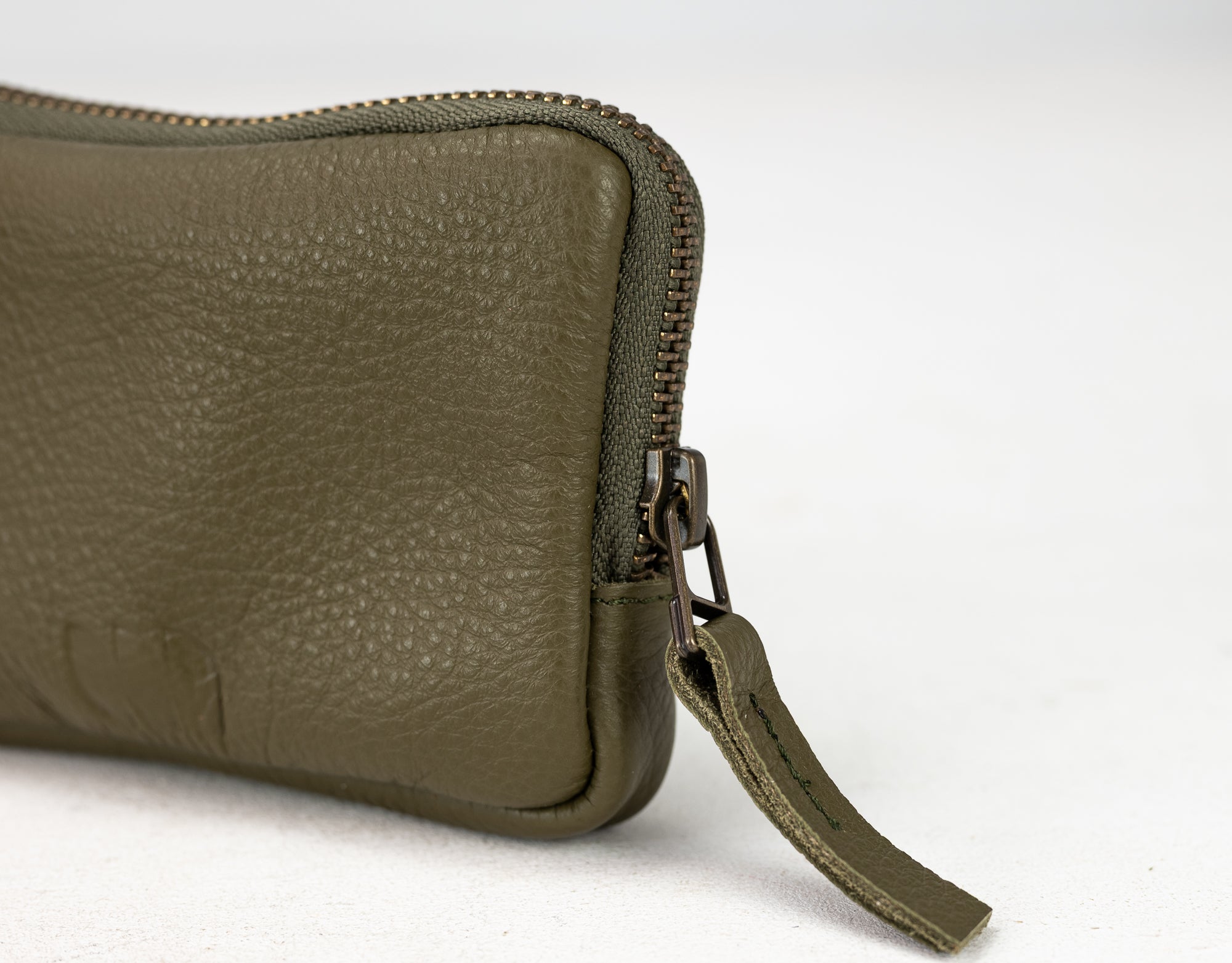 Green leather wallet with a zipper on a white background