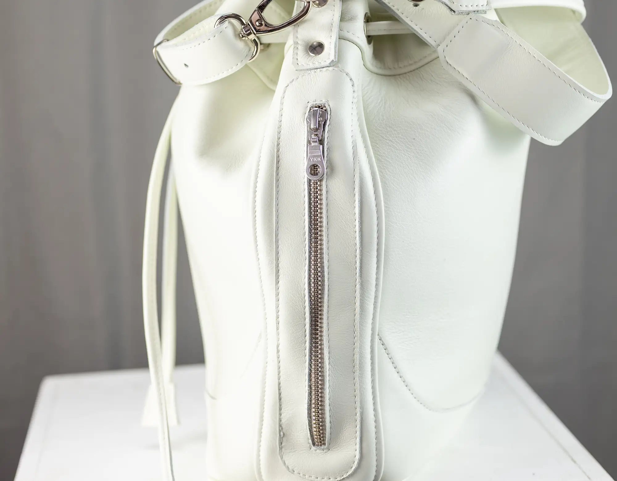 White handbag with a bow on a gray background