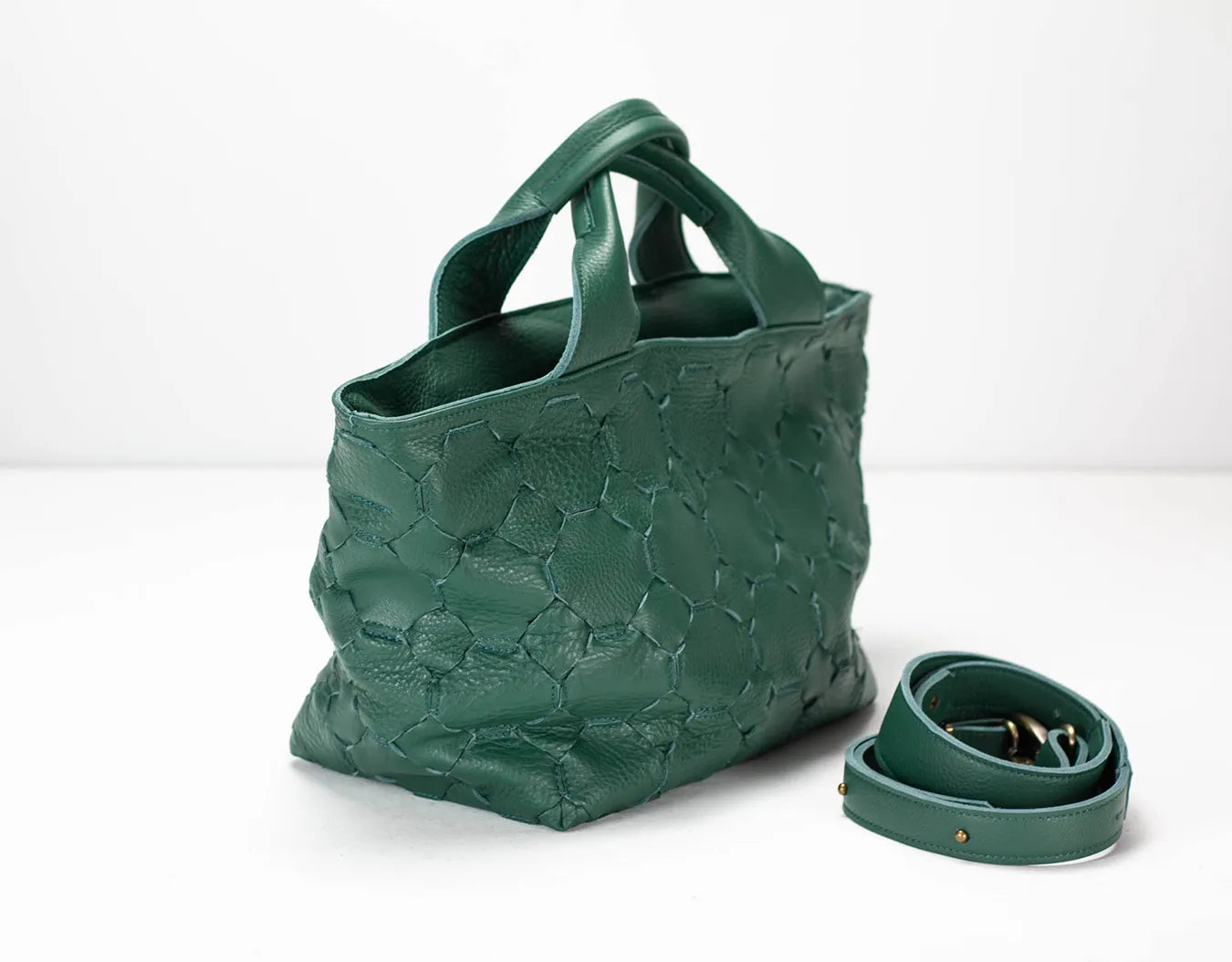 Green textured handbag with matching strap on a white background