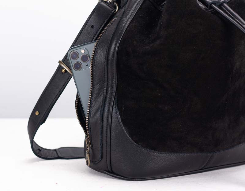 Black leather bag with fur lining on a white background