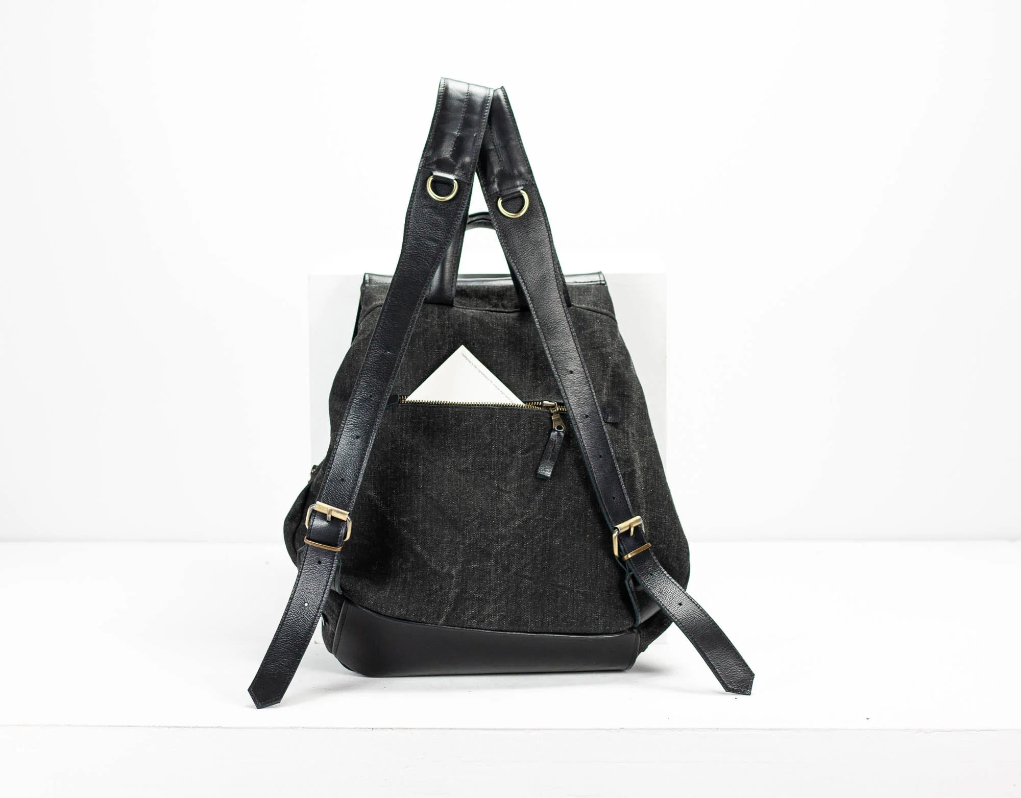 Black backpack with gold buckles on a white background