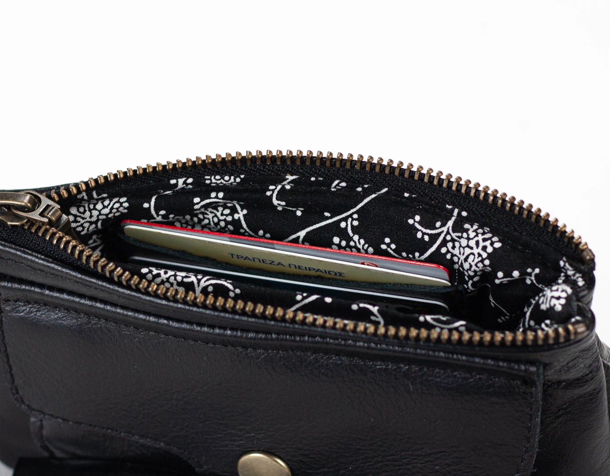 Black leather pouch with floral zipper pull on a white background