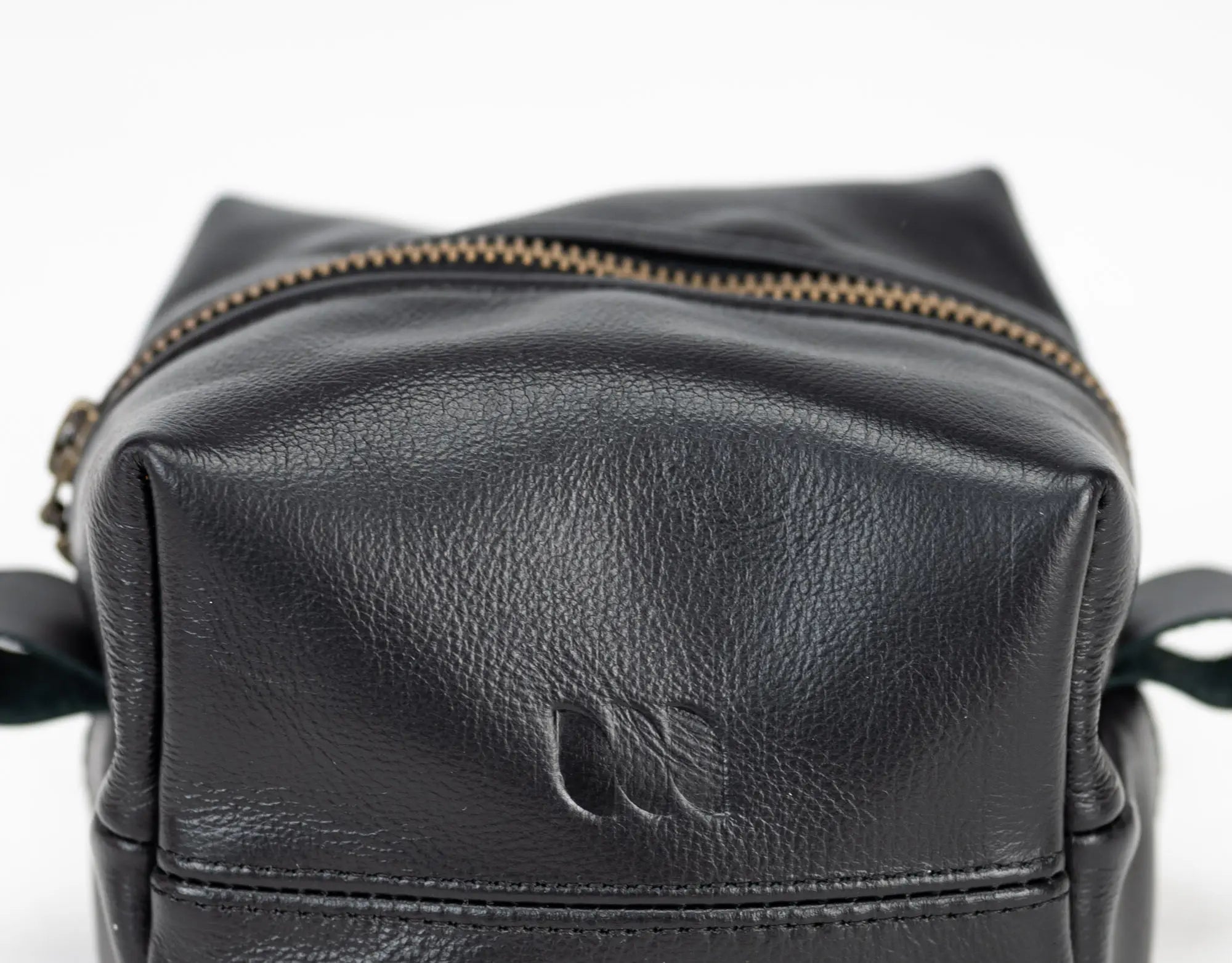 Black leather bag with gold zipper on a white background