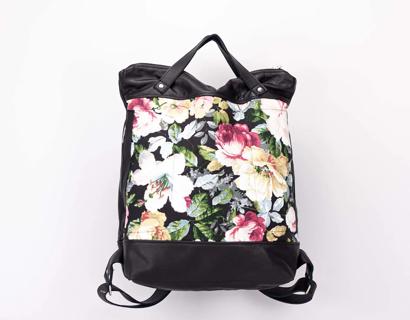 Floral-patterned backpack with black accents on a white background