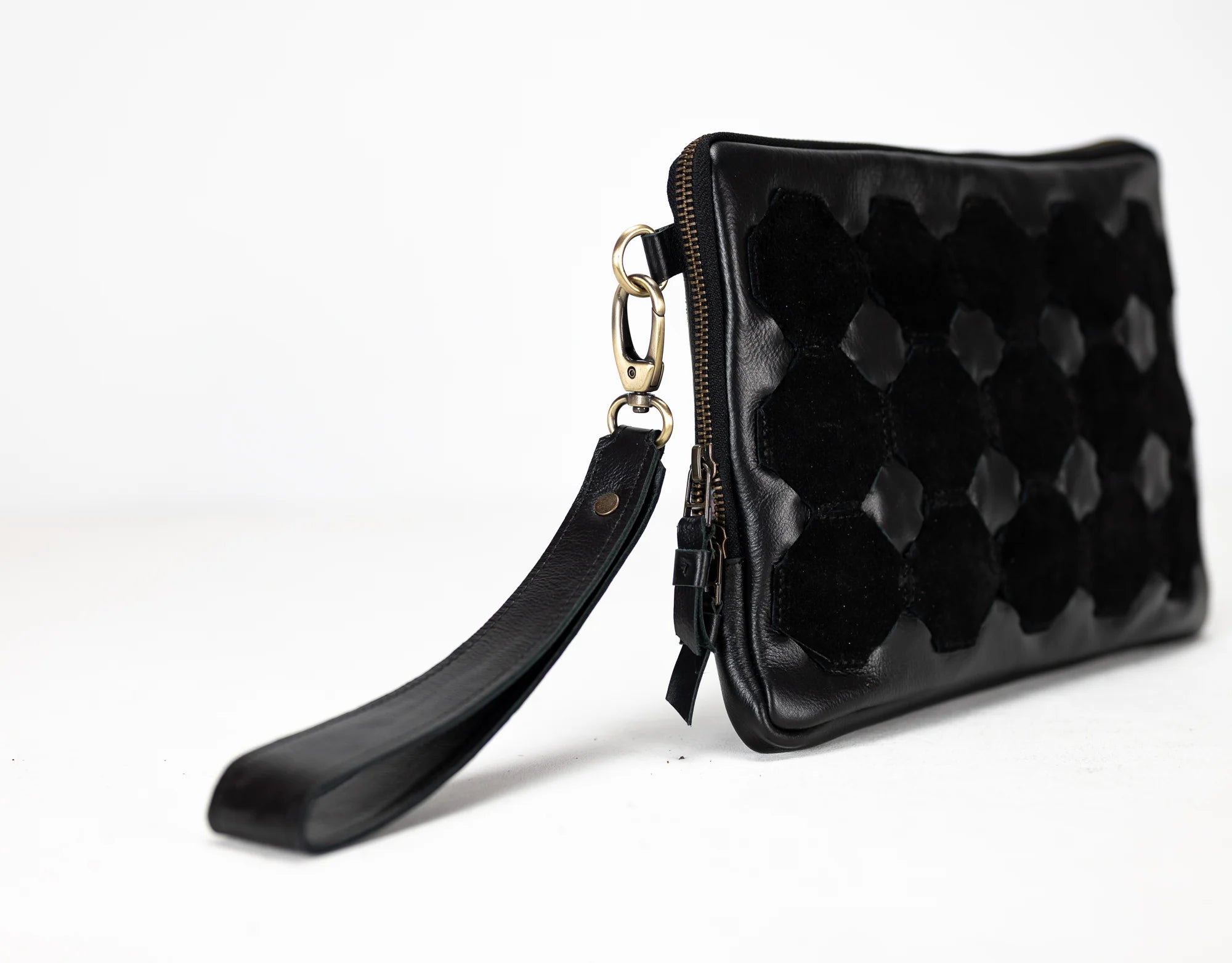 Black quilted clutch bag with a strap on a white background