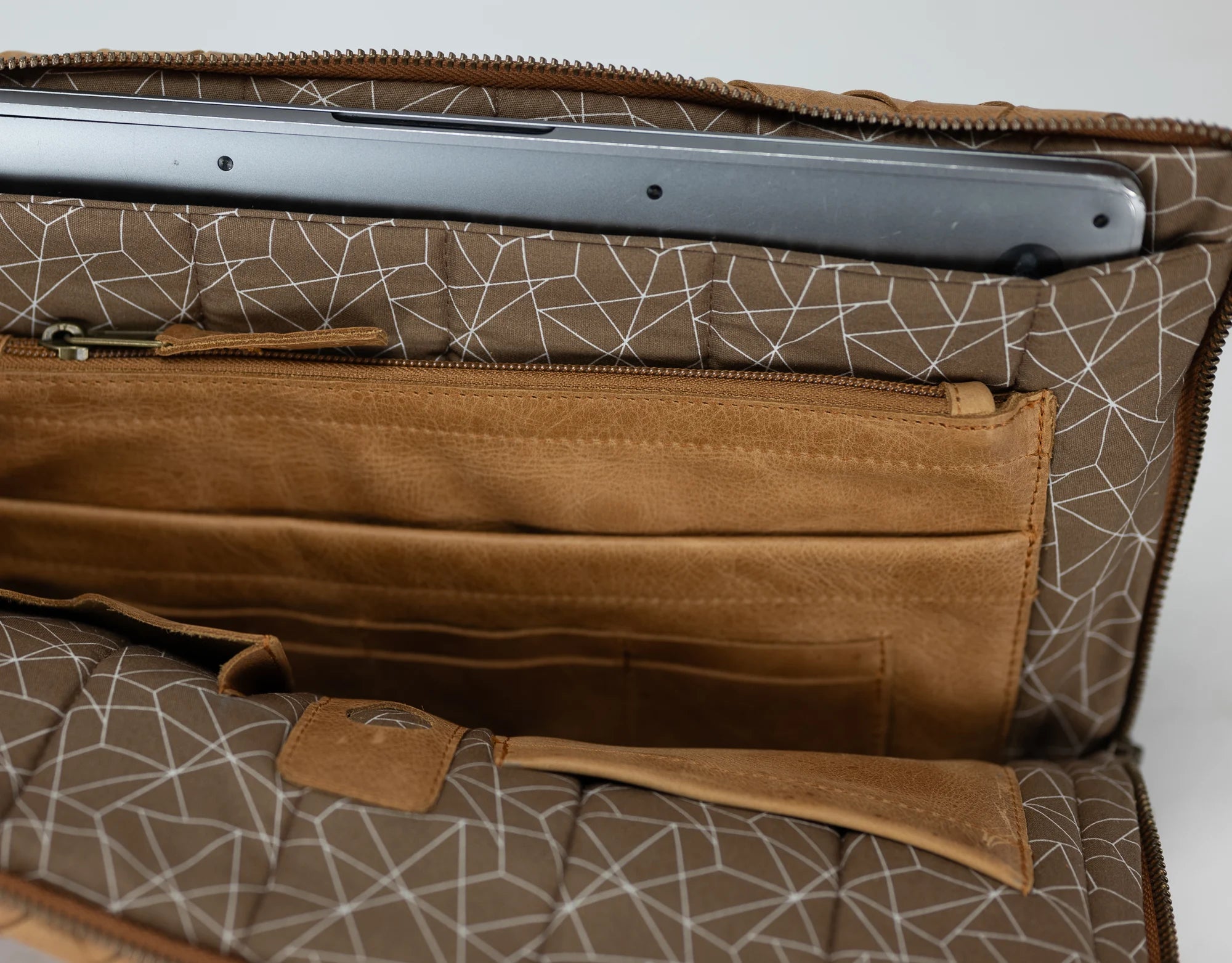 Brown patterned bag with a compartment for a laptop on a white background