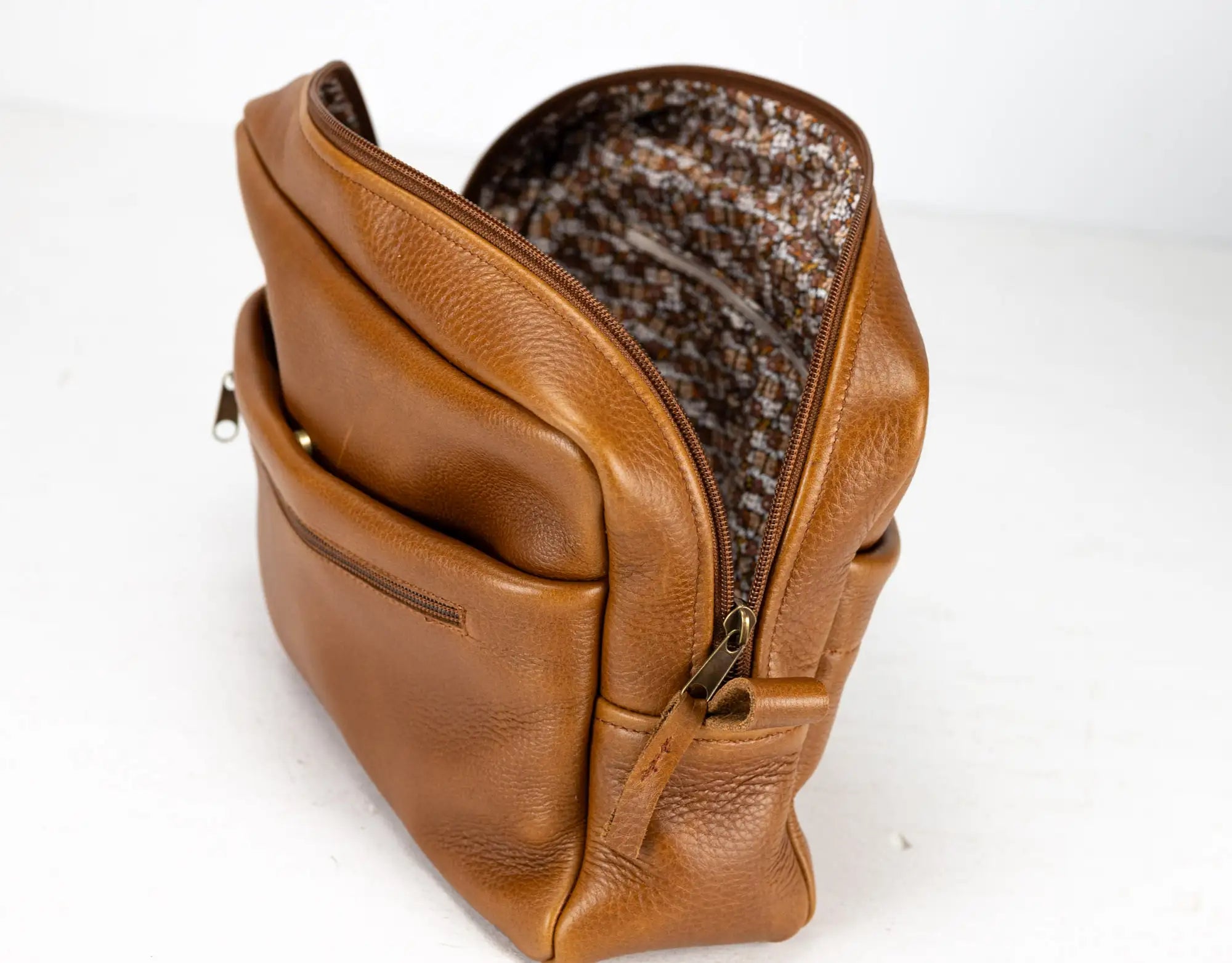 Brown leather bag with a textured interior on a white background