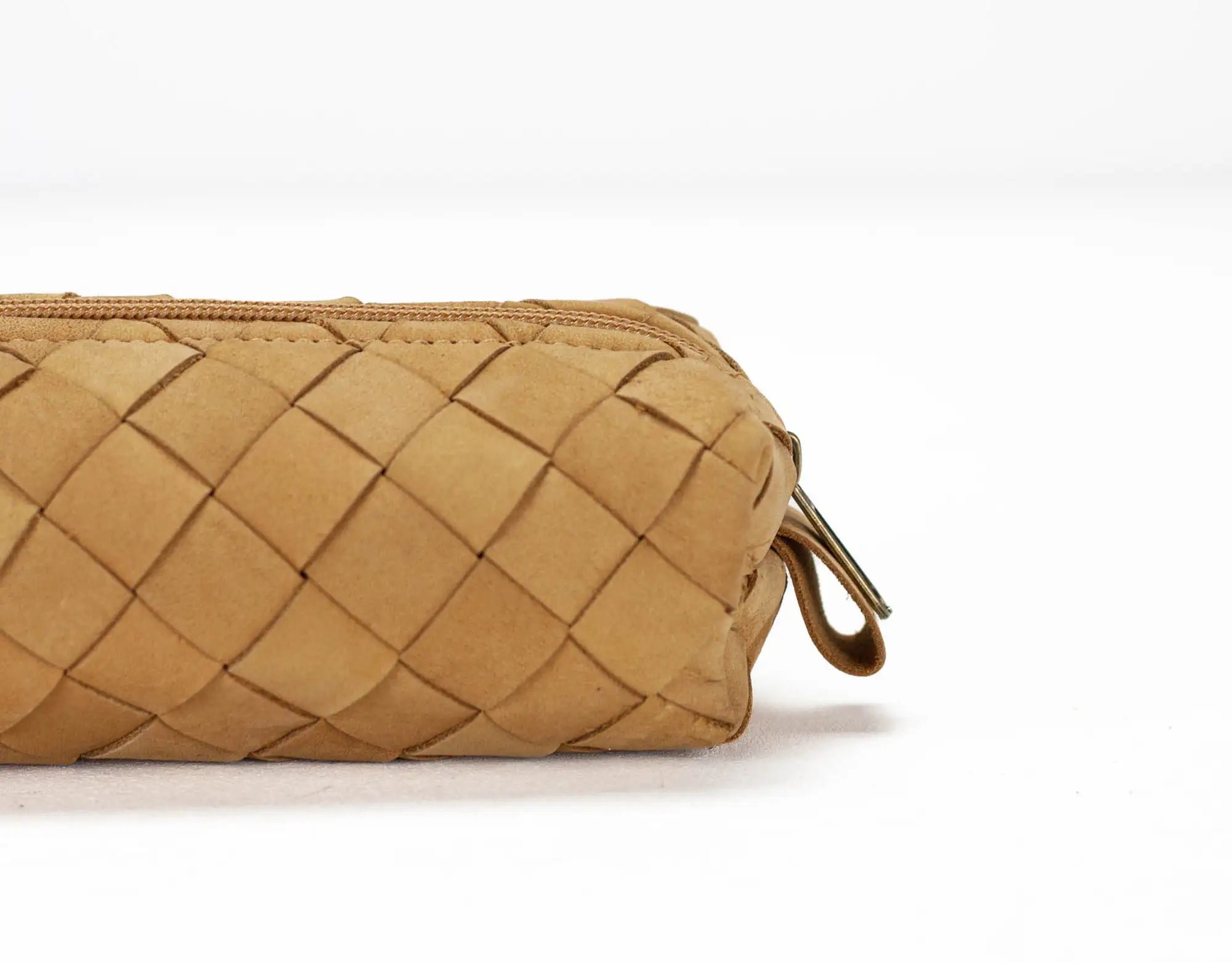 Tan woven clutch bag on a white background