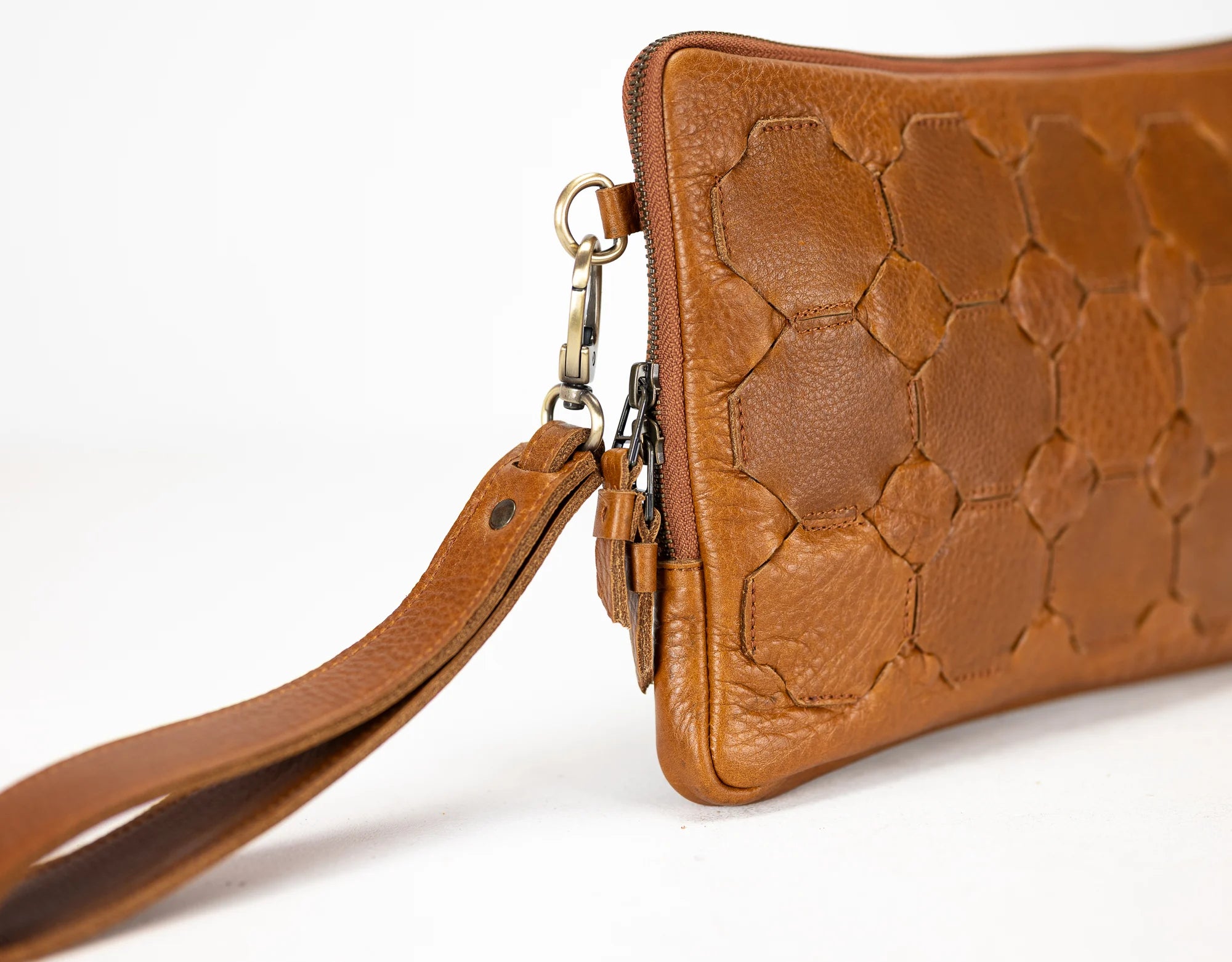 Brown leather handbag with a textured pattern on a white background