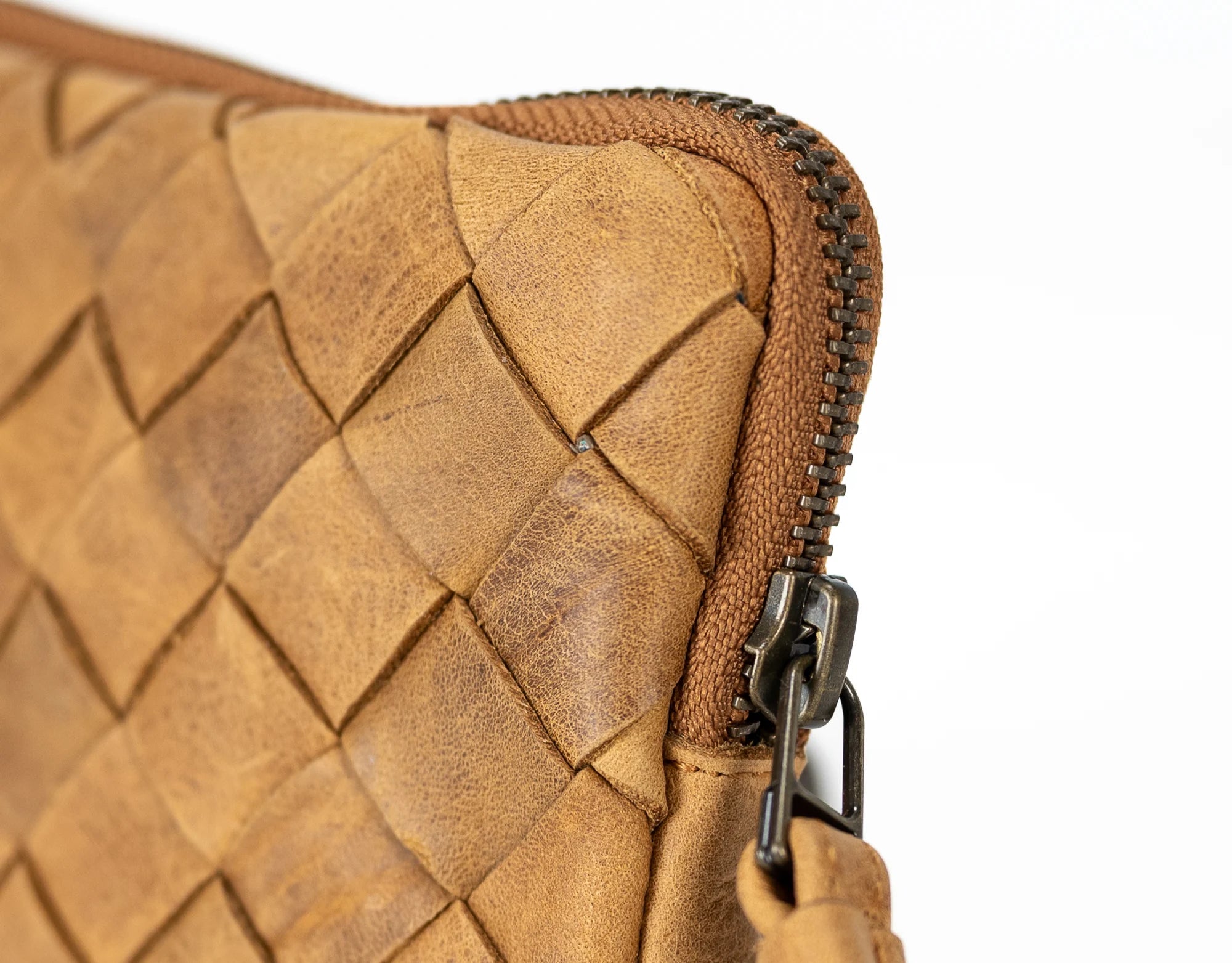 Close-up of a brown woven leather pouch with a zipper.