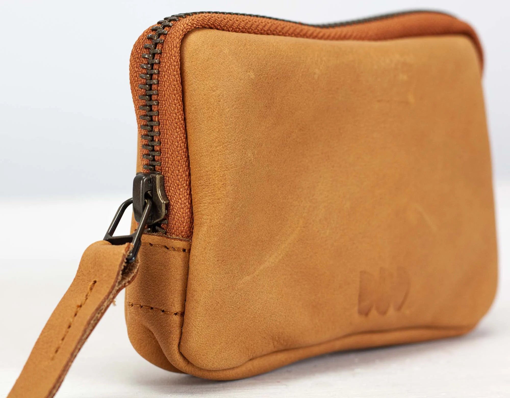 Brown leather pouch with zipper on a white background