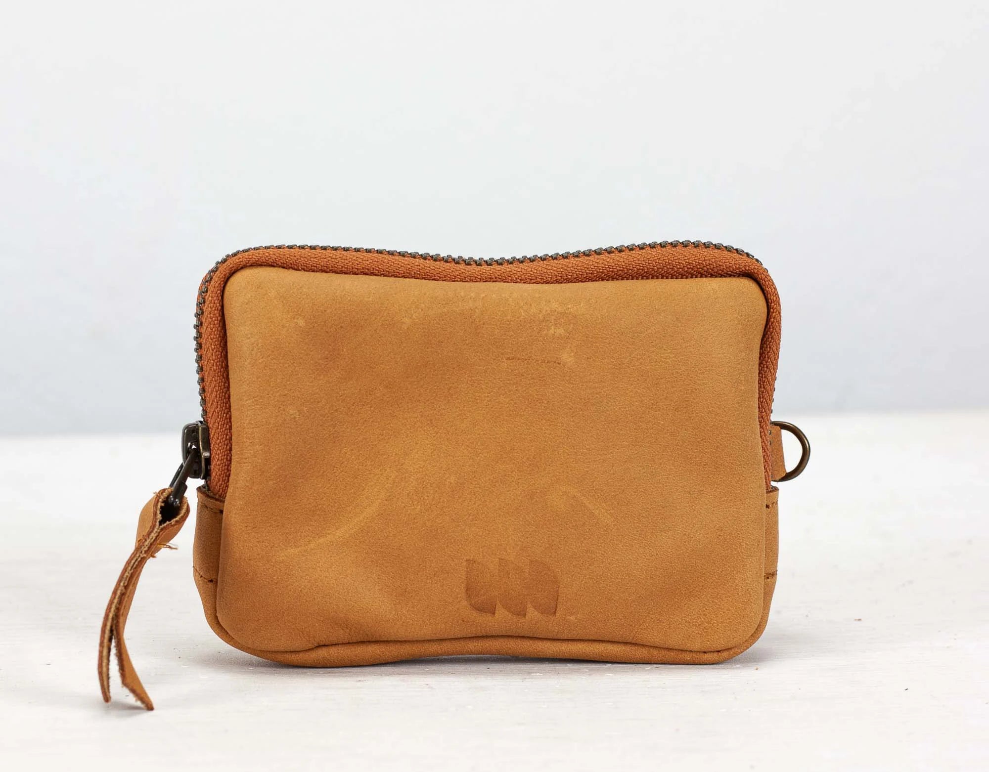 Brown leather pouch with a brand logo on a white background