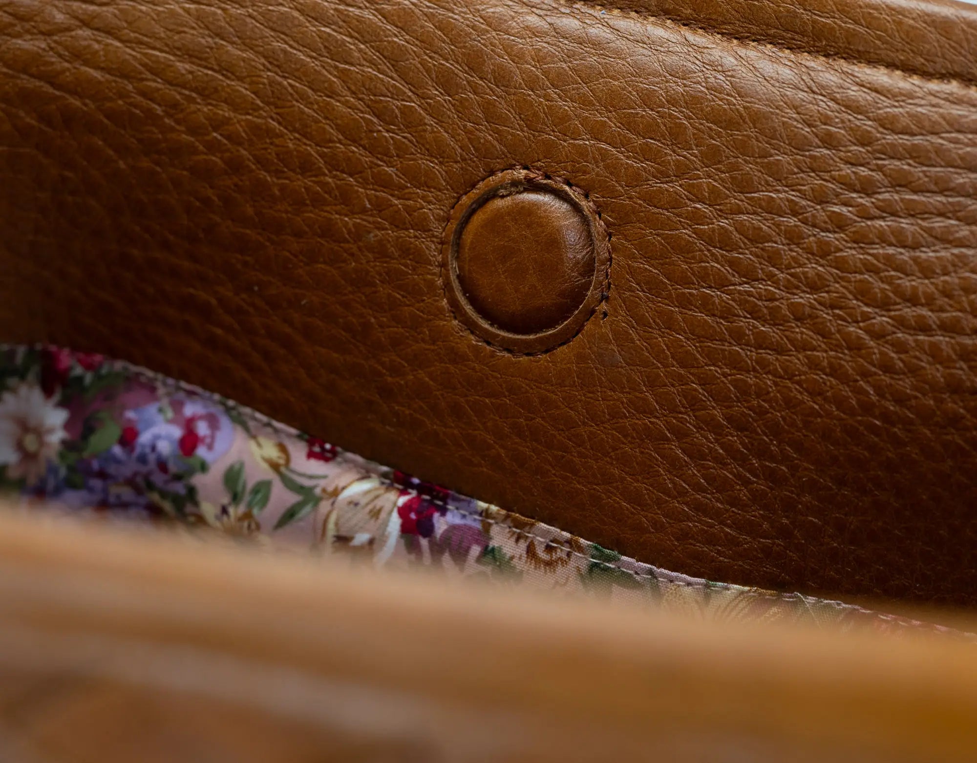 Close-up of a brown leather bag with floral lining