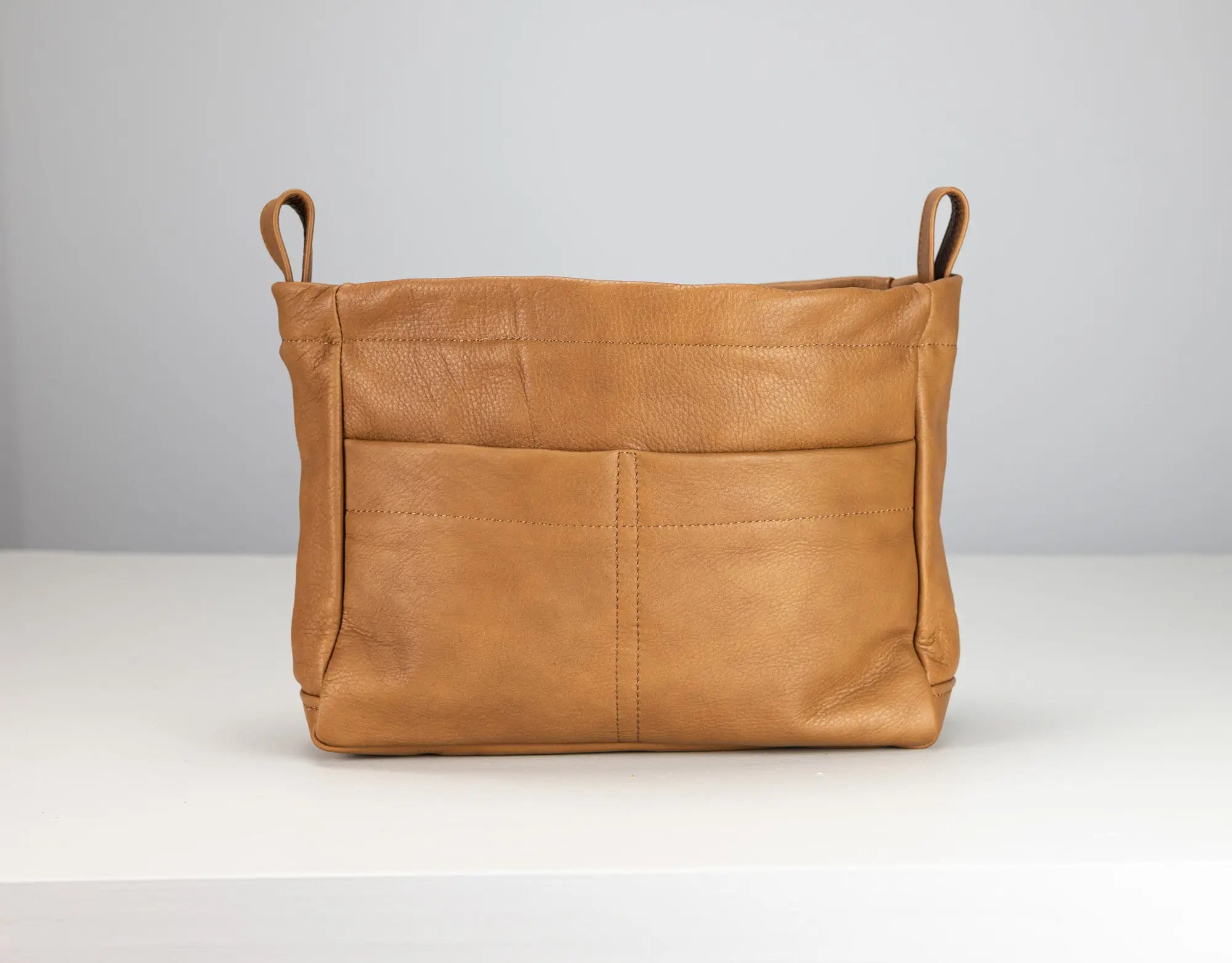 Brown leather bag with handles on a white background