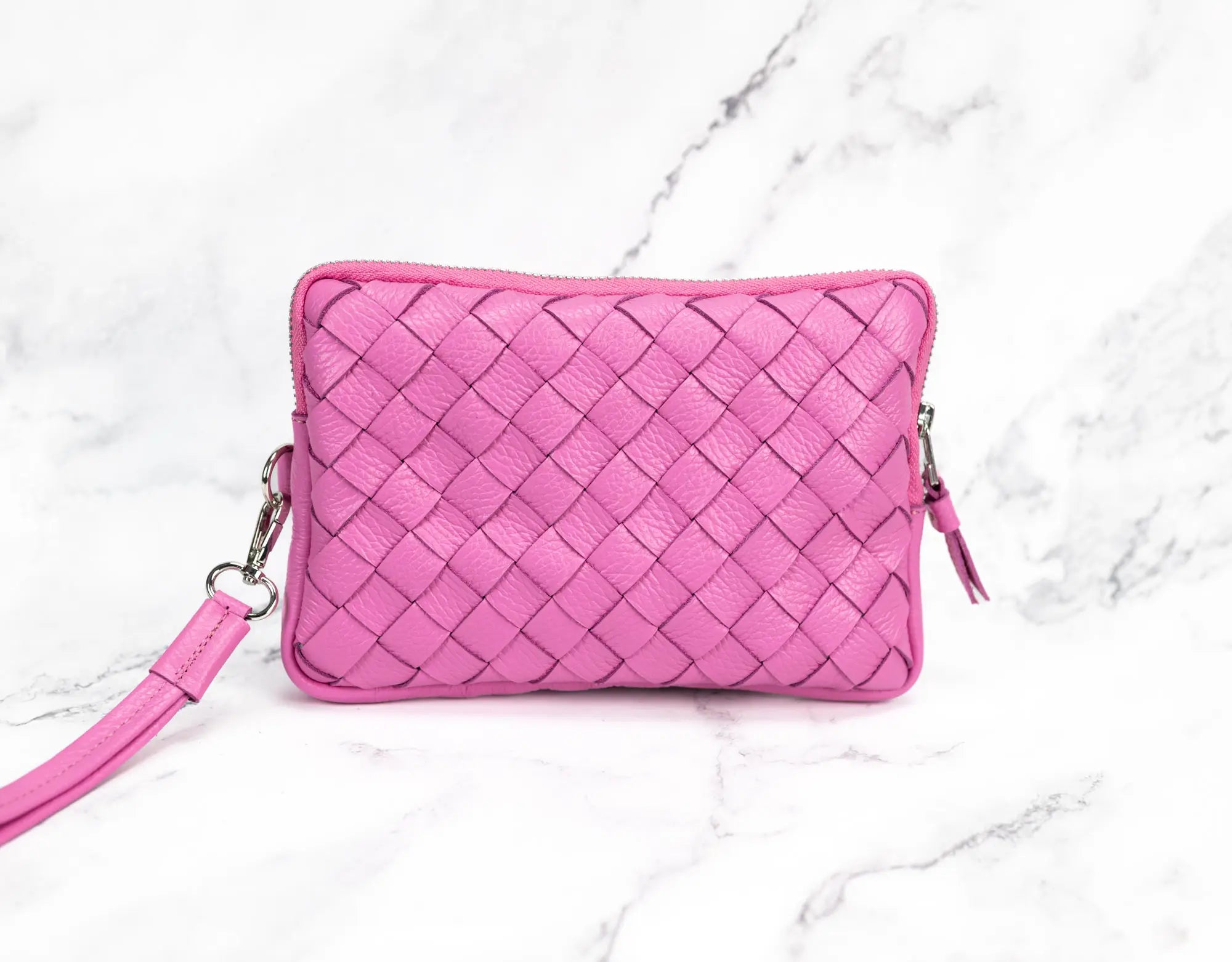 Pink woven handbag on a marble background