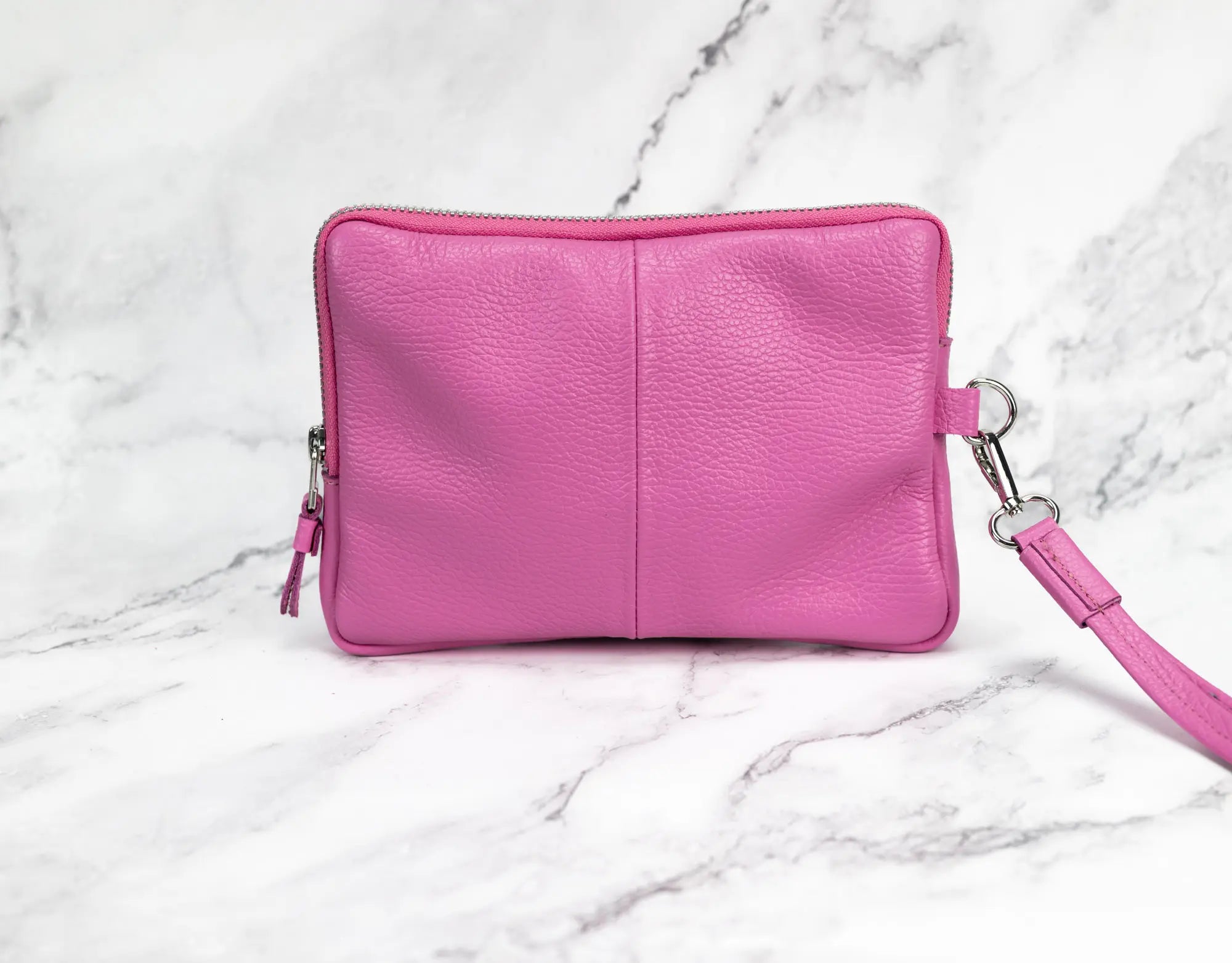 Pink leather handbag on a marble surface
