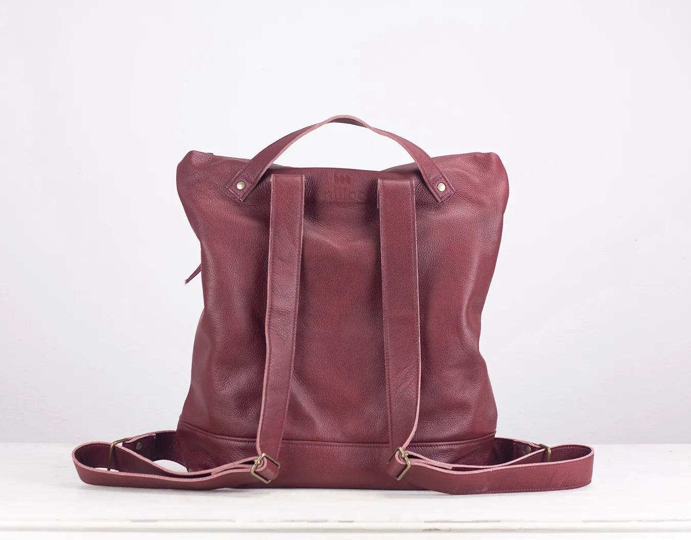 Maroon leather tote bag on a white background