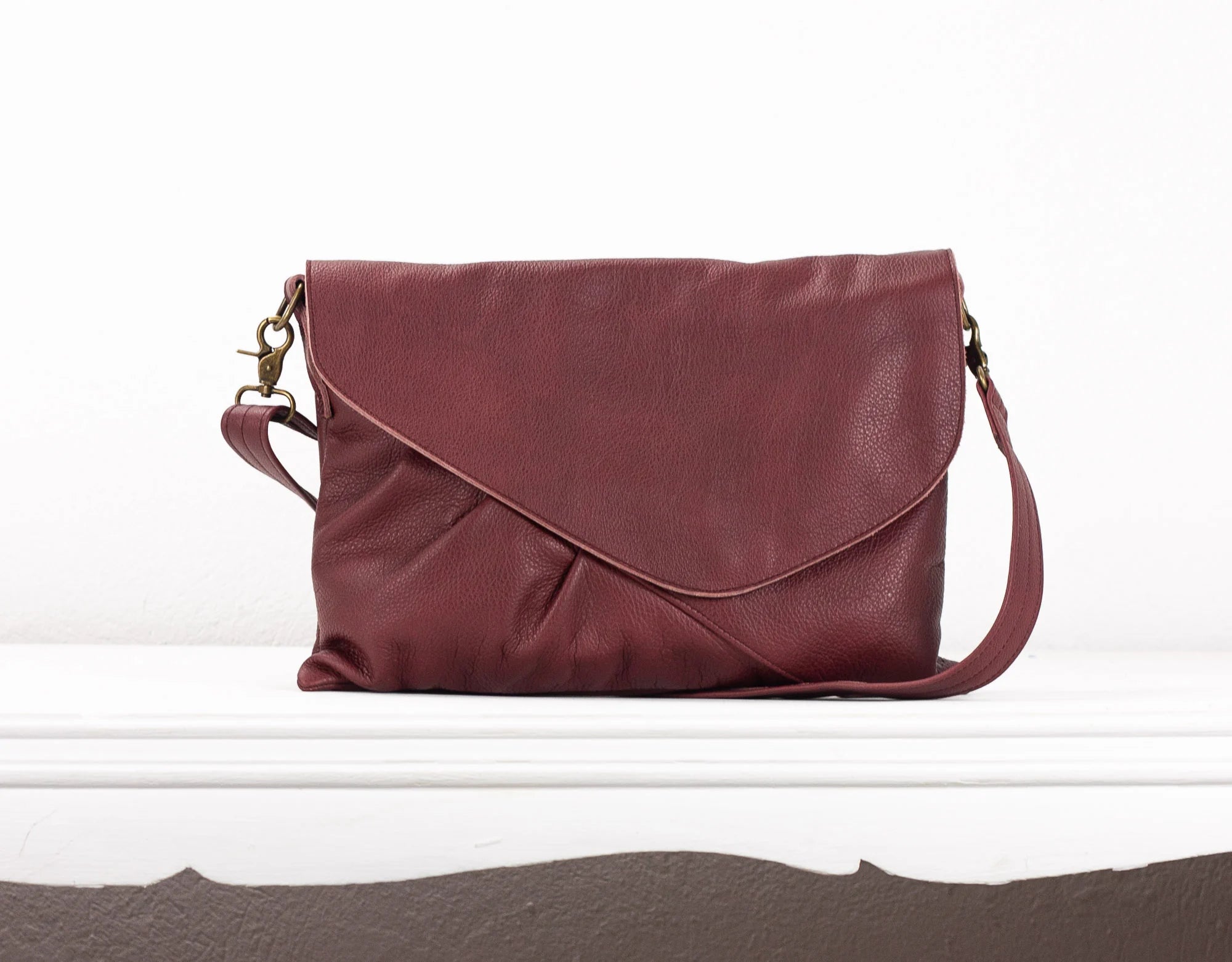 Maroon leather handbag on a white background