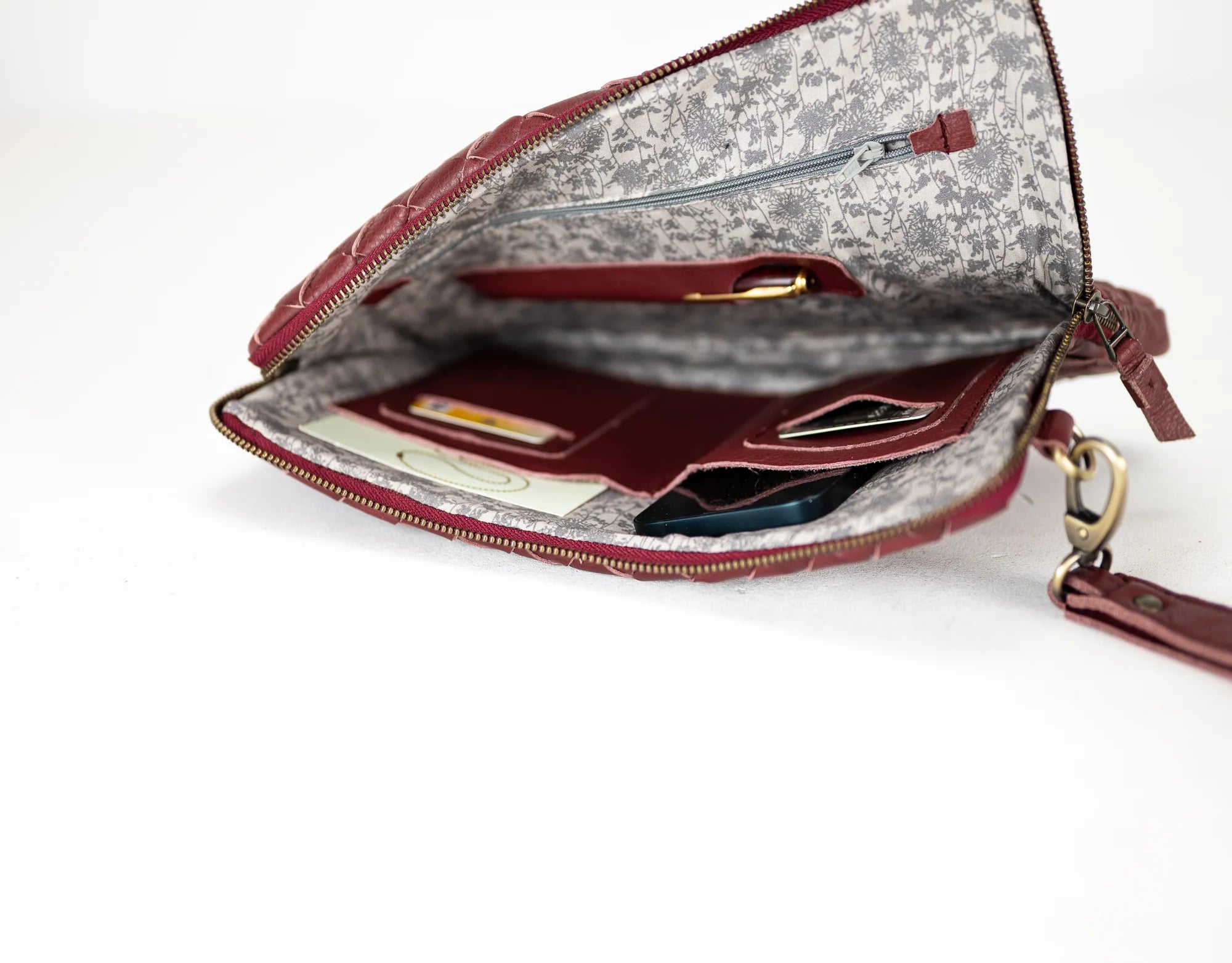 Open handbag with floral interior on a white background