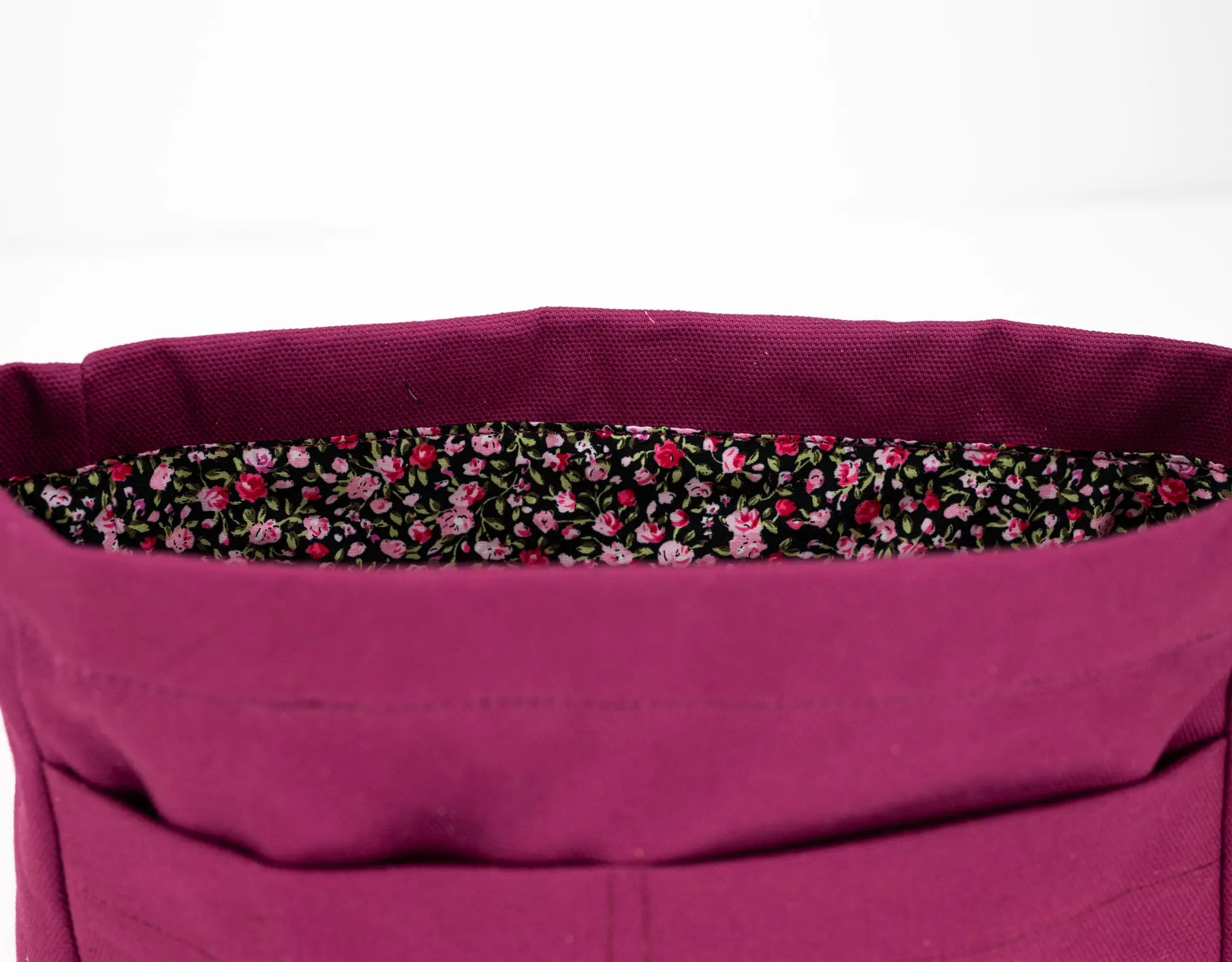 Close-up of a purple bag with a floral lining on a white background