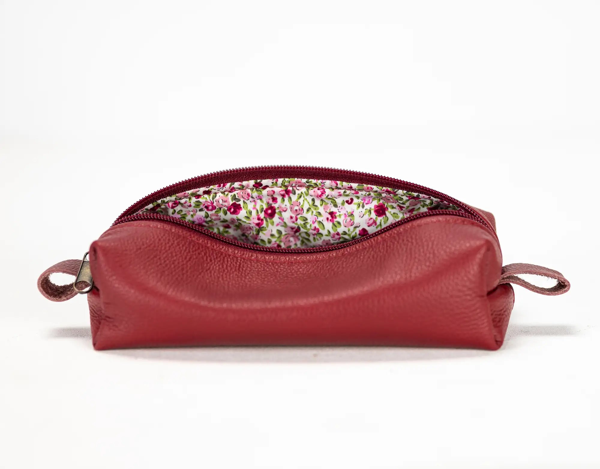 Red leather pouch with floral lining on a white background