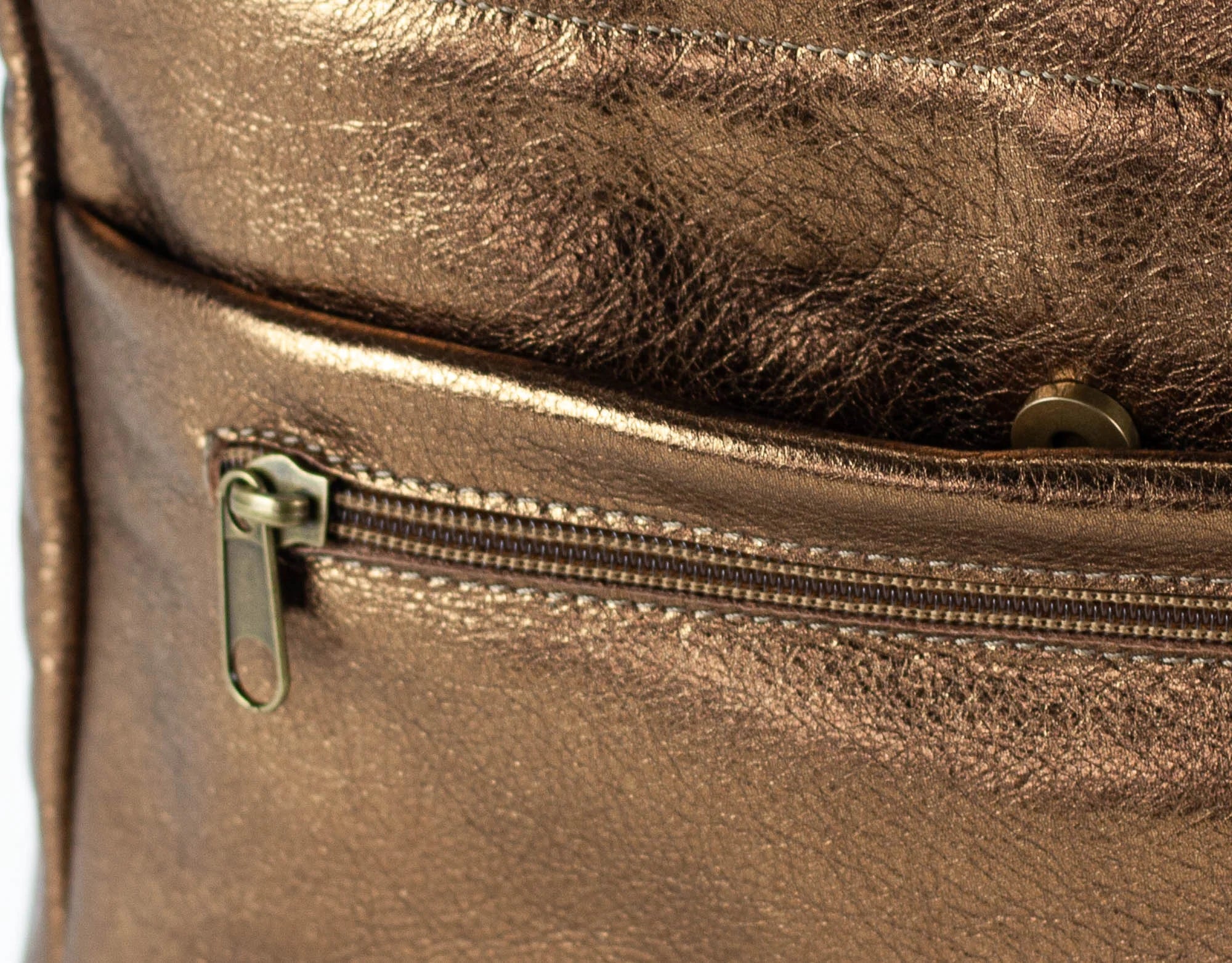 Close-up of a bronze leather bag with a zipper