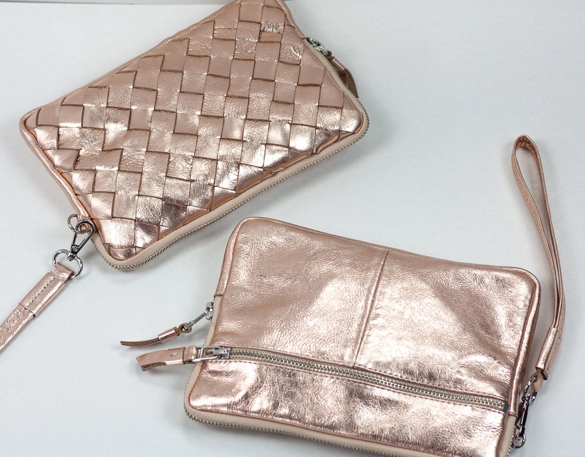 Two rose gold handbags with woven pattern on a light gray background