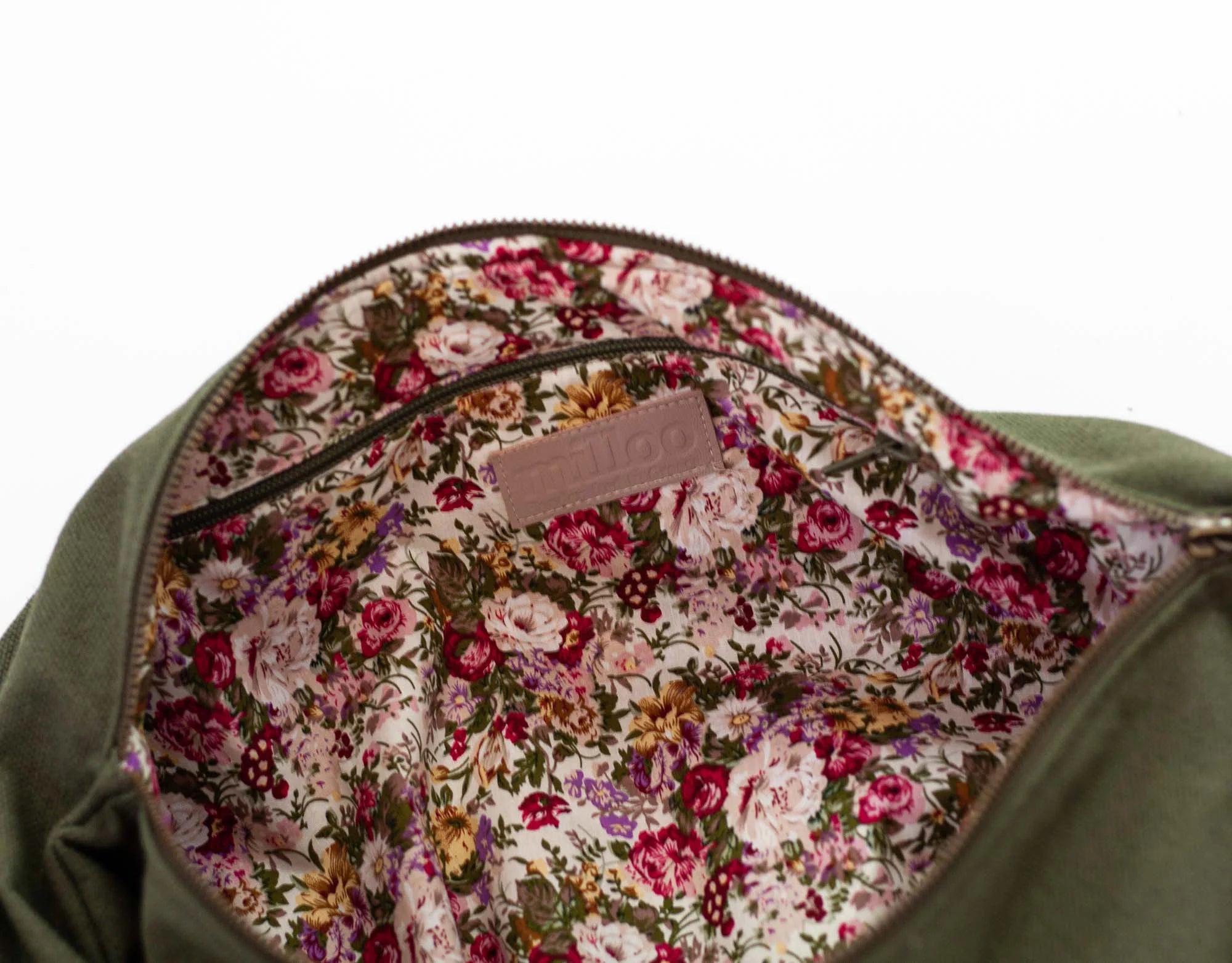 Floral-patterned lining of a bag with a visible brand label on a white background