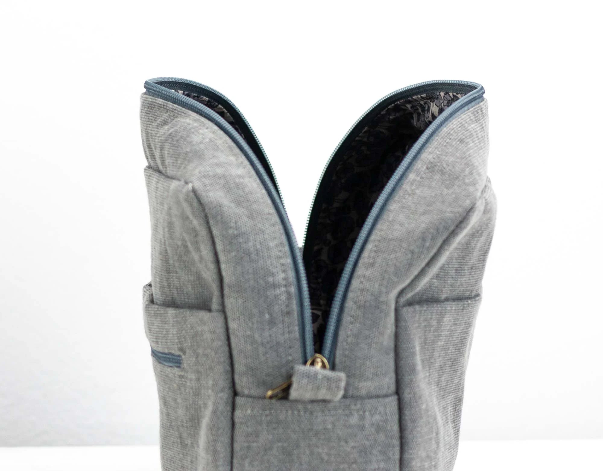 Gray backpack with blue zipper on a white background