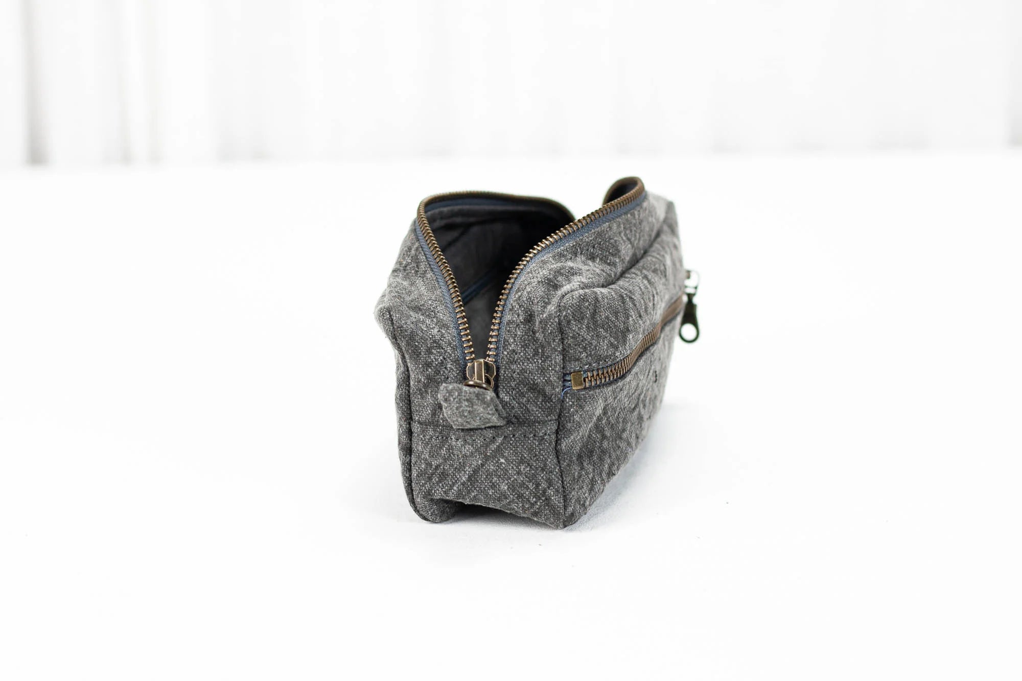 Gray textured pouch with a zipper on a white background