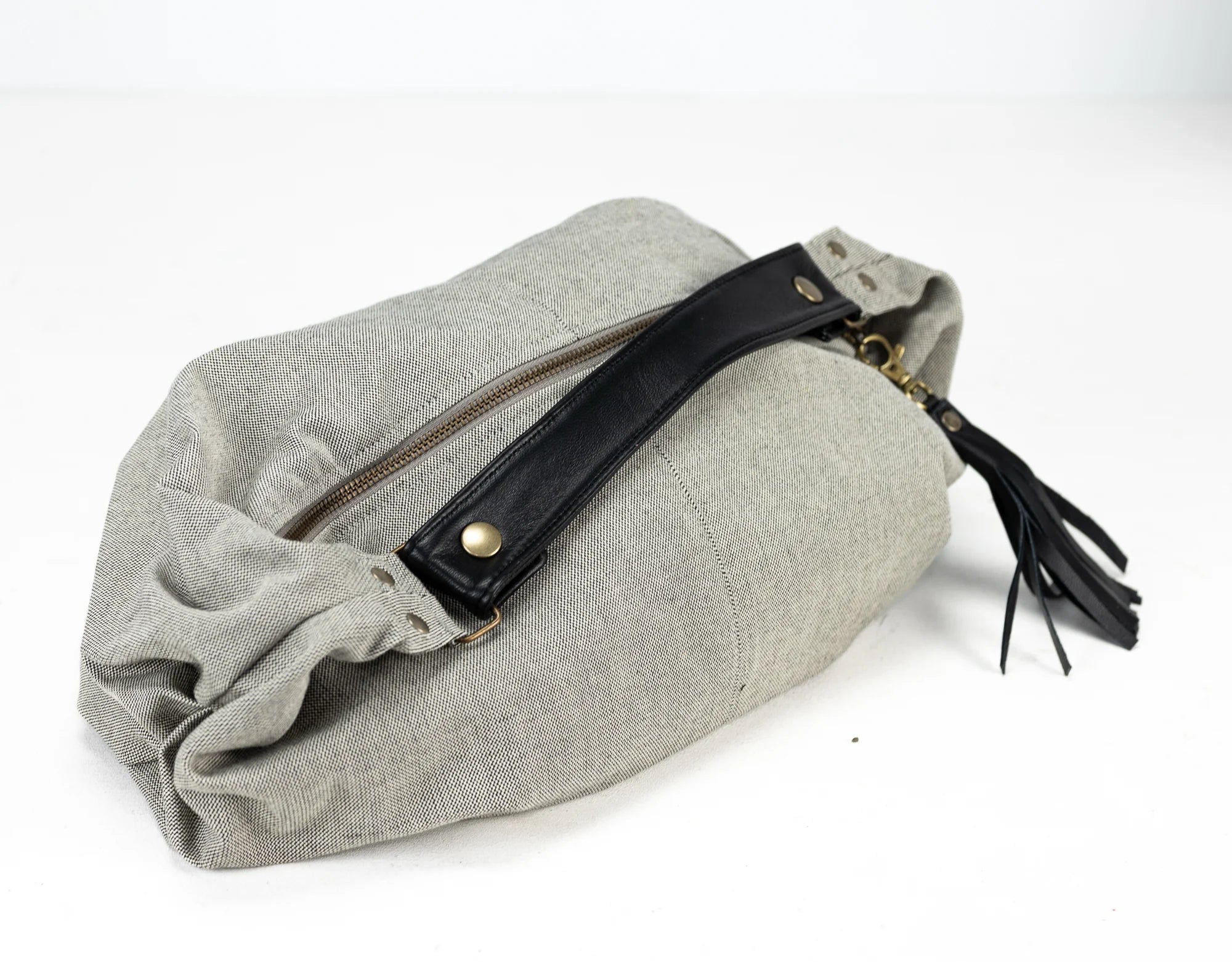 Gray pouch with a black zipper and tassel on a white background