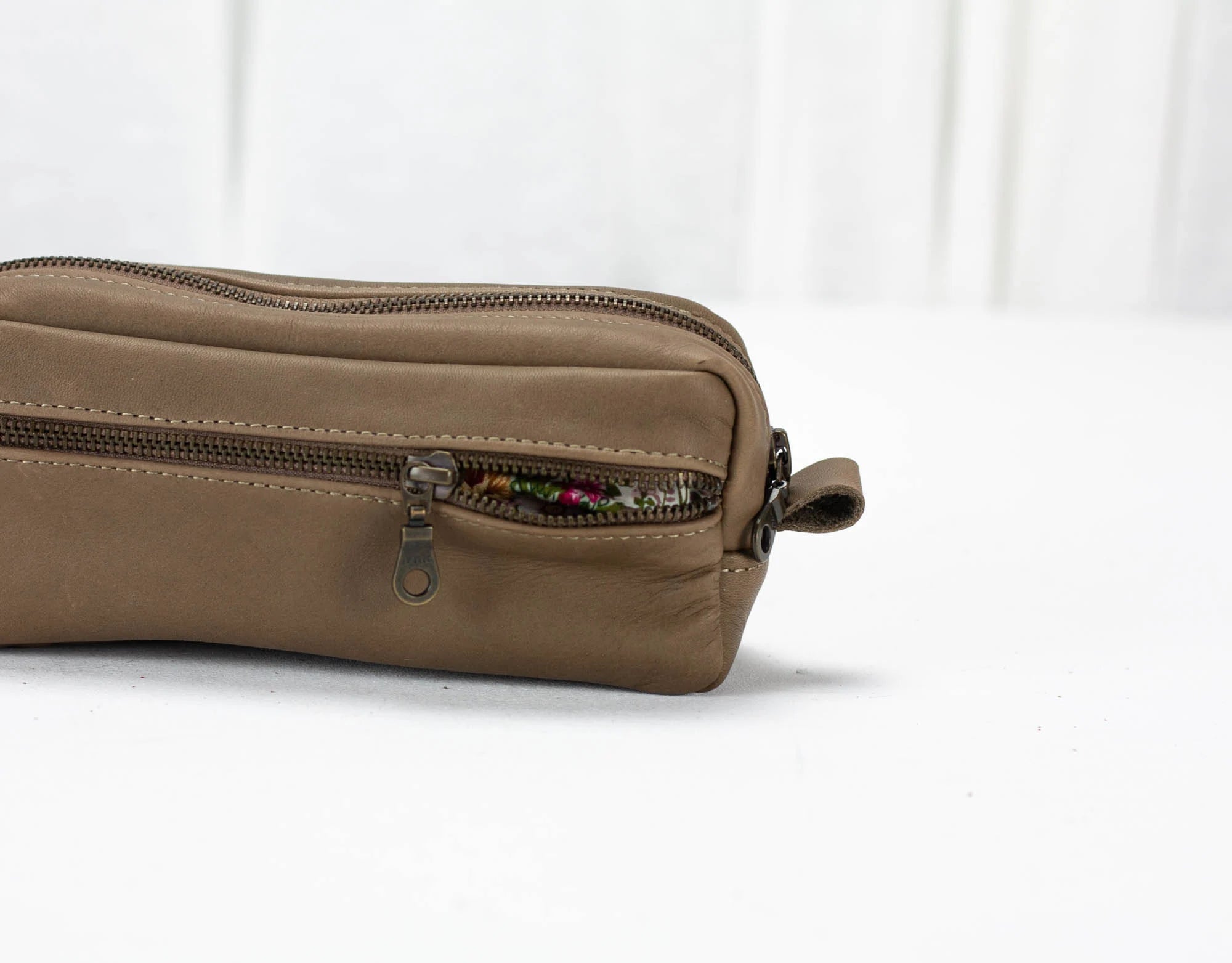 Brown leather pouch with a zipper on a white background