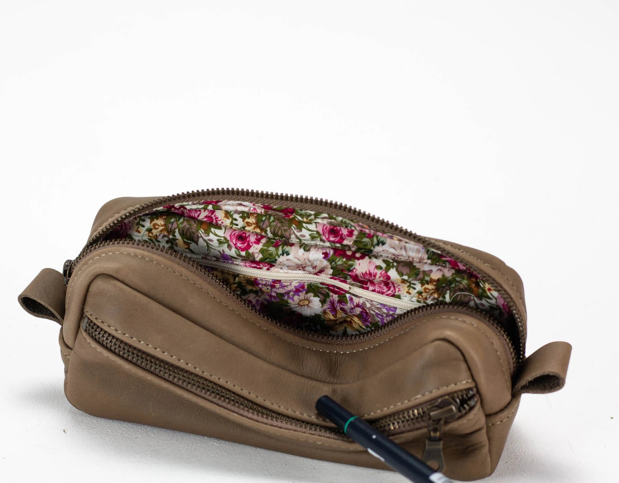 Brown leather pouch with floral interior on a white background